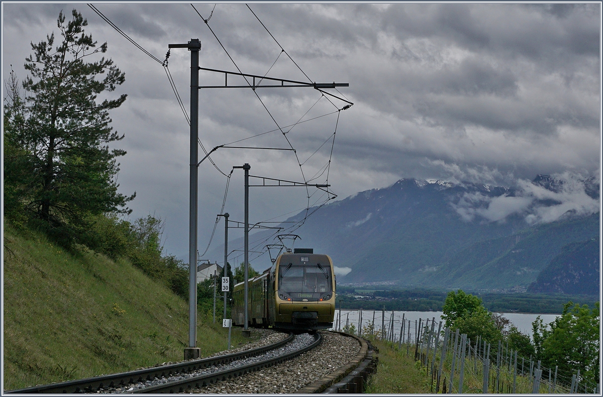 Unter dunklen Wolken auf dem Weg nach Montreux ist dieser MOB  Lenkerpendel  als Regionalzug 2209 kurz nach Planchamp. 

2. Mai 2020