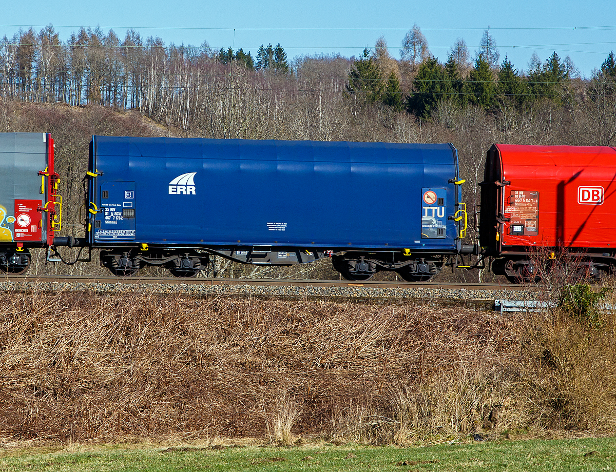 Vierachsiger Drehgestell-Flachwagen mit verschiebbarem Planenverdeck und Lademulden fr Coiltransporte, 35 81 4677 172-2 A-RCW, der Gattung Shimmns-ttu, eingestellt durch die Rail Cargo Wagon - Austria GmbH, jedoch mit Werbung auf Plane der ERR - European Rail Rent GmbH, am 02.03.2022 im Zugverband bei der Zugdurchfahrt bei Rudersdorf (Kr. Siegen).

Diese Wagen sind speziell fr den Transport witterungsempfindlicher Blechrollen (Coils) bestimmt. Er besitzt feste Stirnwnde, 5 fest im Untergestell eingebaute Lademulden. Die Wagenabdeckung erfolgt mit einer PVC-beschichteten Gewebeplane, die auf 11 Rohrrahmen aufliegt. ber Laufwagen ist das Planendach in Wagenlngsrichtung verschiebbar. Die Verriegelung des Planendaches an den Stirnwnden erfolgt ber eine 4-Punkt-Zentralverriegelung, die sowohl vom Erdboden als auch von der Rampe aus bedient werden kann. Das Planenverdeck lsst sich an einem Wagenende so weit zusammenschieben, dass ca. 2/3 der Ladeflche zur Beladung freigegeben wird. Hierdurch ist eine einfache Beladung des Wagens sowohl von oben als auch von der Seite aus mglich. 

TECHNISCHE DATEN:
Spurweite: 1.435 mm
Achsanzahl: 4 (in 2 Drehgestelle)
Lnge ber Puffer: 12.040 mm
Lnge der Ladeflche: 10.800 mm
Drehzapfenabstand: 7.000 mm
Achsabstand im Drehgestell: 1.800 mm
Eigengewicht: 21.547 kg
Hchstgeschwindigkeit:  100  km/h (beladen) / 120 km/h (leer)
Maximales Ladegewicht: 68,4 t (Streckenklasse D4)
Kleinster bef. Gleisbogenradius: 35 m
Bauart der Bremse: KE-GP-A (K), max. 58 t
Intern. Verwendungsfhigkeit: RIV