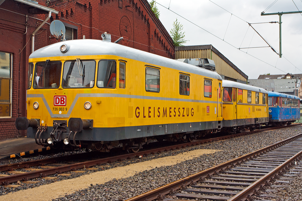 
Von der anderen Seite und Fortsetzung der Beschreibung (siehe Vorgönger Bild)...
Der Gleismesszug 725 002-0 / 726 002-9 der DB Netz Instandhaltung ist am 16.08.2014 im Südwestfälischen Eisenbahnmuseum in Siegen ausgestellt.

Der Messwagen BR 726:
Dieser entspricht in der Grundkonstruktion der Ausführung des Regelturmtriebwagens BR 701. Auf geringer Verwindung und Durchbiegung ist durch Längs- und Querträger mit entsprechenden Widerstandsmomenten besonderer Wert gelegt worden.

Der Gleismesswagen besteht aus dem Messraum und einem Führerstand. In der Mitte des Messraumes befindet sich der Messtisch, an dem die Auswertung der Messergebnisse erfolgt. Eine Werkbank ermöglicht der Bedienungsmannschaft kleinere Reparaturen. Die Stromversorgung der Messeinrichtung erfolgt durch ein 220/380 V-Dieselstromaggregat, das im Triebwagen untergebracht ist. Zur Verständigung mit dem Zugführer im Triebwagen ist eine Wechselsprechanlage vorhanden.

Die Messwagen verfügen über eine spezielle Federung, um den Wagen unabhängig von seiner Beladung und dem Verlauf des Fahrwegs stets waagerecht und in konstanter Höhe über der Schienenoberkante zu halten. Dies ist notwendig, um eine ausreichende Genauigkeit der Messergebnisse sicherzustellen.

Die Messung geschieht  mechanisch, mittel unter dem Wagenkasten angebrachten absenkbaren Achsen. Diese registrieren die Gleisparameter, um sie dann auf dem Messtisch anzuzeigen. Diese mechanische Messtechnik gilt inzwischen als überholt, da digitale Messeinrichtungen mittels Ultraschallprüfung oder Lasertechnik eine höhere Genauigkeit erreichen. Zudem können diese bei höheren Geschwindigkeiten betrieben werden, während die Messgeschwindigkeit der Baureihe 725/726 auf 80 km/h begrenzt ist.

Technische Daten der BR 726:
Spurweite: 1.435 mm (Normalspur)
Laufachsen: 2
Länge über Puffer/Kupplung: 13.400 mm
Breite: 3.000 mm
Achsabstand: 6.000 mm
Laufraddurchmesser:  850 mm 
Eigengewicht: 18 t
Nutzlast: 1,0 t
Zul. Anhängelast:   -
Zur Mitfahrt zugel. Personen: 15
Höchstgeschwindigkeit:  90 km/h

Die Wagen (BR 725 mit BR 726) sind miteinander durch Scharfenbergkupplungen verbunden, an den anderen Enden der Fahrgestelle sind normale Seitenpuffer und Schraubenkupplungen angebracht. 

Der Messzug ist auch für Steilstrecken der DB zugelassen, bei der Talfahrt beträgt dann die zulässige Höchstgeschwindigkeit 25 km/h.
