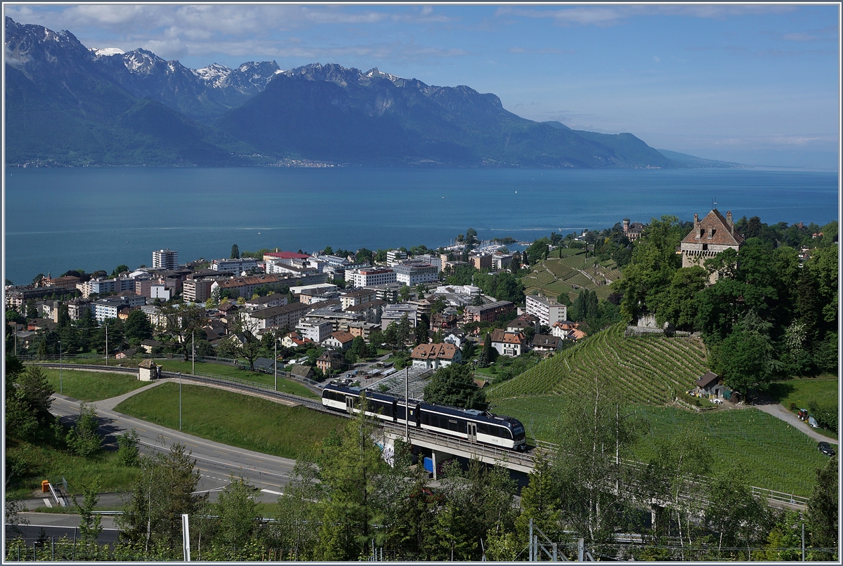 Vor dem Hintergrund des Genfers See und der Savoyer Alpen überquert ein CEV MVR ABeh 2/6 Zug bei Châtelard VD auf einer Brücke gerade die Autobahn A9. 

10. Mai 2020
