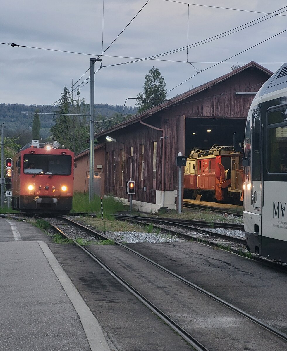Während in morgengrauen im linken Bildteil die MOB HGem 2/2 2501 (ex MVR) rangiert, sind in Dépôt die beiden CEV He 2/2  Nr. 1 und 2 zu erkennen.
Die Aufnahme entstand in Blonay.
23. April 2025