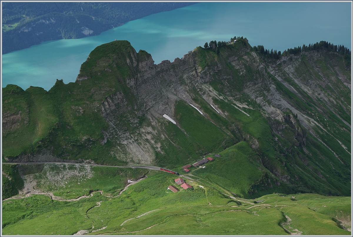 Während im oberen Bildteil der im Tal gelegene Brienzersee mit seinem türkischgrünen Wasser funkelt, zeigt sich mitten im Bild ganz klein ein BRB Dampfzug in der Kreuzungsstation Chüematt. 

8. Juli 2016