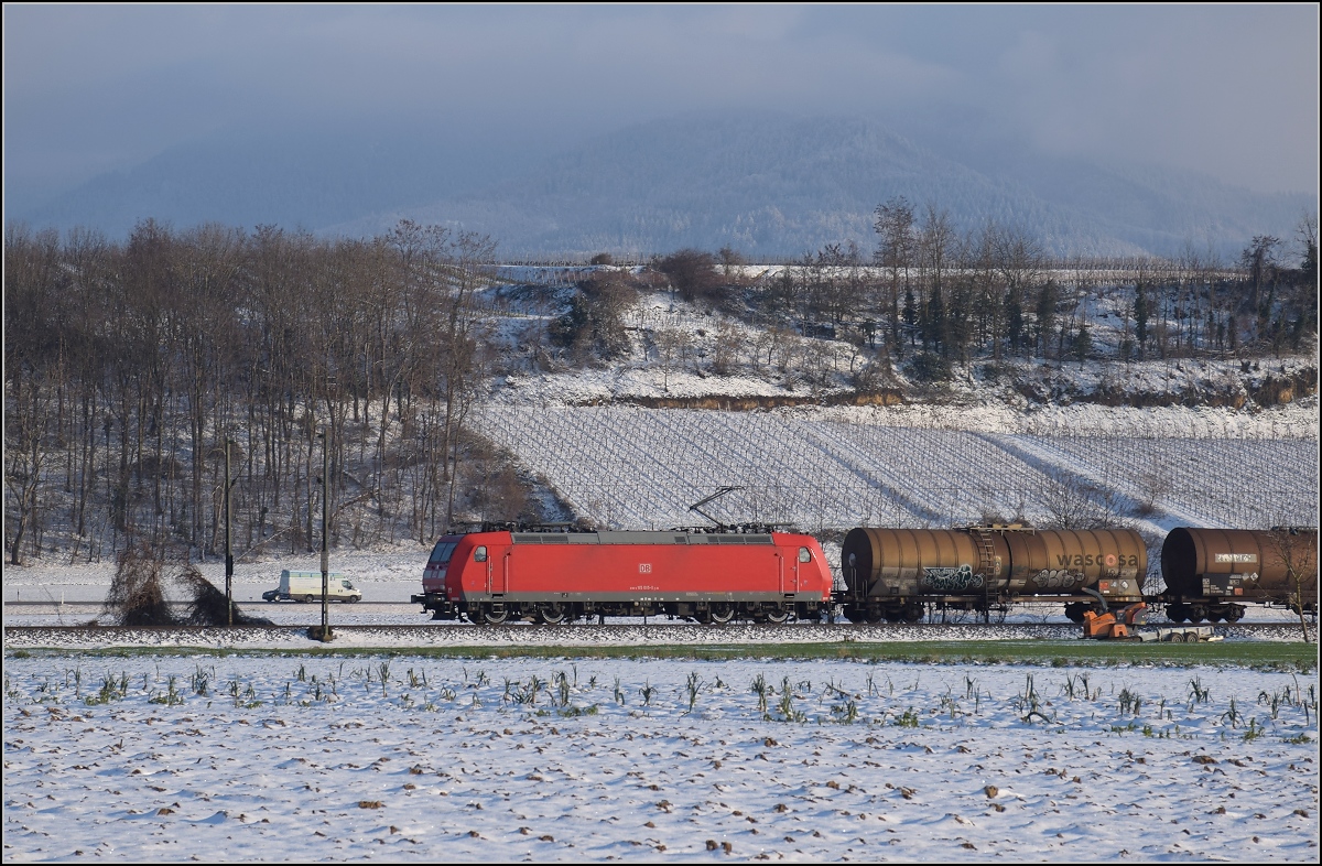 Zwischen Belchensystem und Blauendreieck. 

Captrain 185 085 ist bei Buggingen nordwärts unterwegs. Februar 2021.