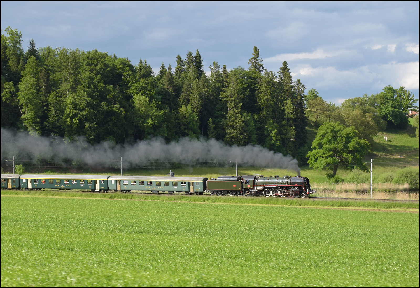 150 Jahre Emmentalbahn. 

141-R-1244 auf dem Rückweg von der grossen Emmentalrundfahrt anlässlich des Jubiläums. Am Ortsausgang Menznau findet die Sonne ein Wolkenloch, freie Sicht auf die Strecke und die Strasse ist ohne Verkehr. Menznau Tuetisee, Mai 2025.