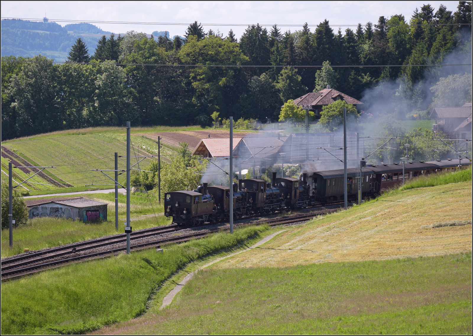 150 Jahre Emmentalbahn. Vierfachtraktion auf Gleisen der Bernischen Staatsbahn.

Alle vier momentan betriebsfähigen Dampfloks der Dampfbahn Bern in einem Zug, das ist ein Fest für den Bahnfotografen. Ed 3/4 51 der Bern-Schwarzenburg-Bahn, E 3/3 1 'Lise'des Gaswerks Bern, Ed 3/3 3 'Langnau' der Emmentalbahn und E 3/3 853 der Jura-Simplon-Bahn stänkern den Bahnhof Tägertschi voll. Mai 2025.