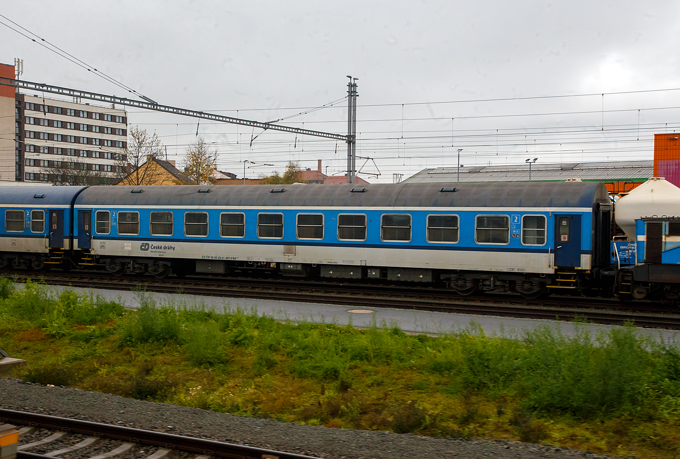 2. Klasse Abteil-Reisezugwagen mit Fahrrad-und Gepäckabteil CZ- ČD 50 54 29-41 497-0 der Gattung Bd 264 der ČD - České dráhy (Tschechische Bahnen) am 24.11.2022 bei Pilsen (Plzeň).

Diese Abteilwagen wurden 1977 bis 1985 vom VEB Waggonbau Bautzen gebaut und 2010/11 durch ŽOS ATECO Bubny modernisiert. 

TECHNISCHE DATEN:
Spurweite: 1.435 mm (Normalspur)
Achsanzahl: 4
Länge über Puffer: 24.500 mm
Drehzapfenabstand: 17.200 mm
Leergewicht: 37  t
Höchstgeschwindigkeit: 140 km/h
Sitzplätze: 72 in 12 Abteilen der 2. Klasse (und 2 Klappsitze)
Fahrradstellplätze: 8
