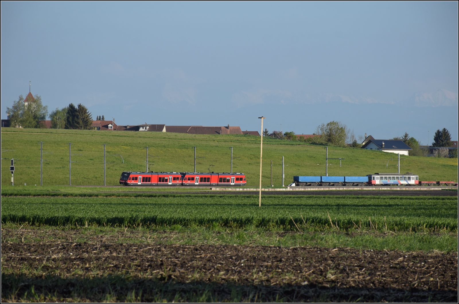 Auf der Biel-Täuffelen-Ins Bahn.

GTW Be 2/6 502 und GTW Be 2/6 507 der ASm. Noch im Bild, drei nicht mehr benötigte Kieswagen Fa 574, Fa 575 und Fa 573, der mittlerweile verschrottete Be 4/4 525 und zwei vermutlich 107 Jahre alte Niederbordwagen, K 587 und K 586. Und bei ganz genauer Betrachtung  zeichnen sich die Alpen in den blauen Himmel. Siselen, April 2022.