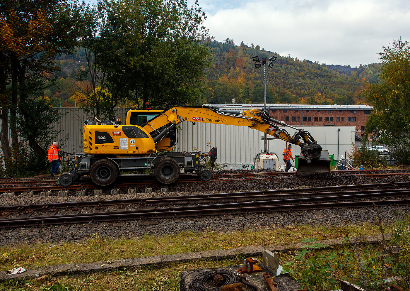 Baustelle Bahnhof Herdorf am 12 Oktober 2025, nun werden die Weichen 25 und 26 eingeschottert. 

Der Liebherr Zweiwegebagger A 922 Rail Litronic mit Abstützpratzen, Kleinwagen Nr. D-KAF 99 80 9904 795-8 (KAF Interne Nr. 10016), der KAF Falkenhahn Bau AG (Kreuztal) muss aushelfen und den Schotter etwas verteilen. Das geht viel schneller als mit Muskelkraft. 