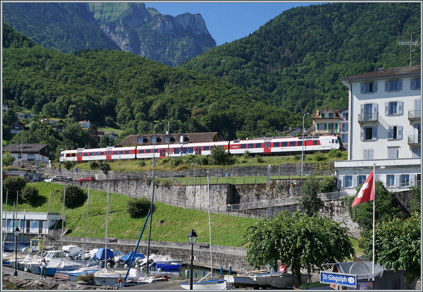 Blick vom Schiff auf  Hafen  und Bahnhof in St-Gingolph; im Bahnhof wendet gerade ein RegionAlps RBDe 560 Domino, wobei da Wenden hier reicht üppig ausgelegt ist: Ankunft xx:06  und Abfahrt XX:51, also gute dreiviertel Stunde.

5. Juli 2024