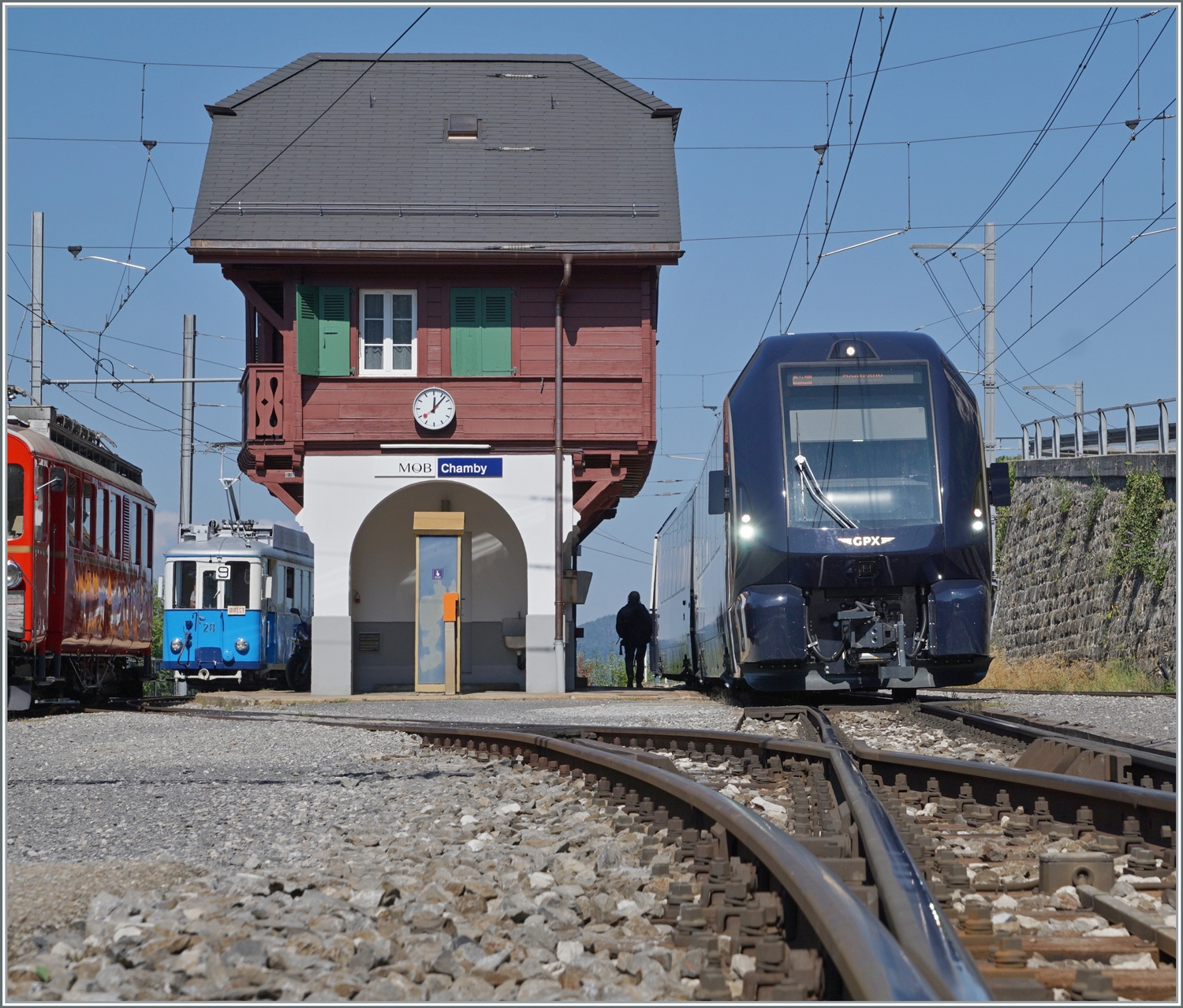 Da der GoldenPass Express von Interlaken Ost nach Montreux in Chamby auf den Gegenzug wartet, ist die Schranke beim Bahnübergang noch geöffnet und somit bietet der Übergang diese Sicht auf den GPX 4065. 

9. Sept. 2023