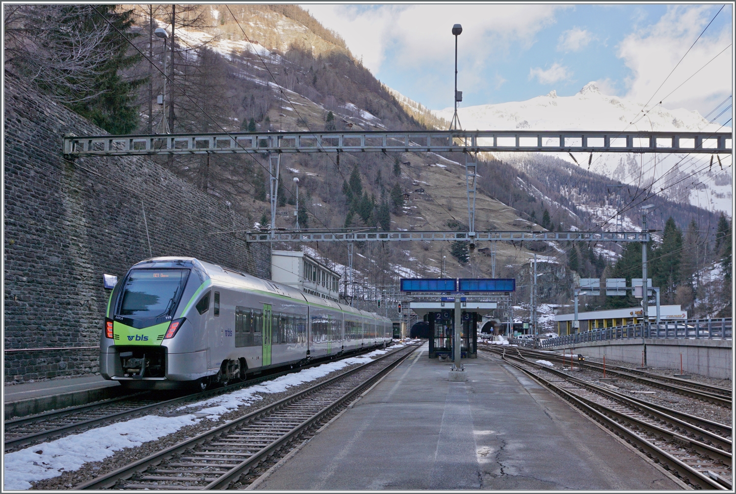 Der BLS RABe 528 115 als RE 1 nach Bern im schattigen Goppenstein, w�hrend auf den Berggipfeln die Sonne scheint. 

3. Jan. 2024