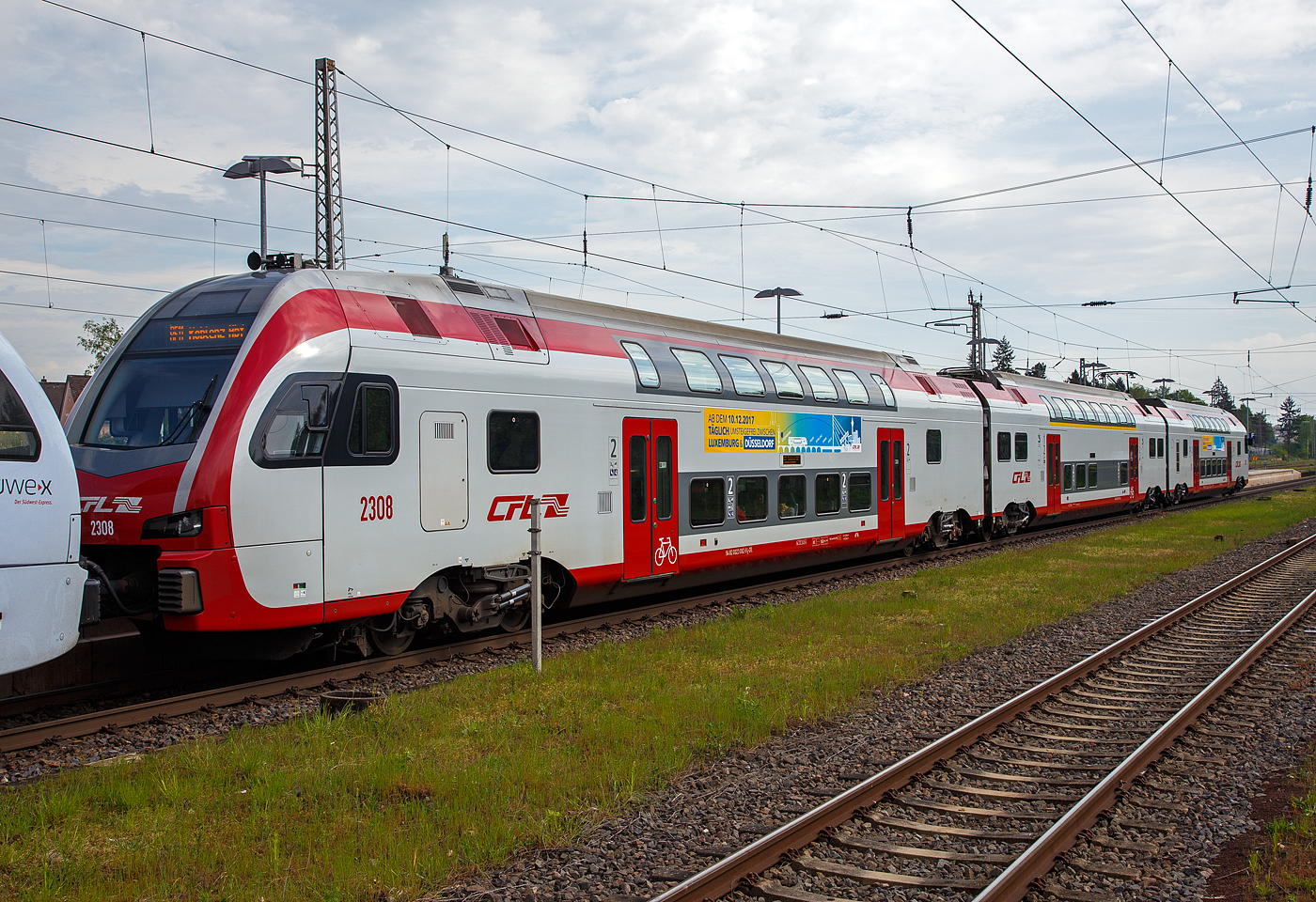 Der dreiteilige CFL Stadler KISS 2308 als RE 11  DeLux-Express  gekuppelt hier am Ende mit dem fünfteilige SÜWEX Stadler FLIRT³  - 429 116 / 429 616 als RE 1  Südwest-Express  nach Koblenz haben am 29.04.2018 den Hbf Wittlich erreicht.

Hier der führende CFL Stadler KISS 2308 als RE 11  DeLux-Express  (Luxembourg – Wasserbillig – Igel – Trier – Cochem –Koblenz). Der KISS setz sich zusammen aus den Wagen 94 82 0023 082-9 L-CFL, 94 82 0023 083-x L-CFL und 94 82 0023 081-1L-CFL. 

Diese ersten 8 KISS der 1.Serie (2301 – 2308) wurden 2013 von der Stadler Pankow GmbH (Berlin) gebaut. Weitere 13 weitere Stadler KISS der 2.Serie (2309 – 2321) wurden 2017 (11 Stück) und 2020 (2 Stück) gebaut, sie besitzen mehr Sitzplätze in der 1. Klasse.

Nach Ankündigung der DB Fernverkehr AG, drei der fünf bestehenden IC-Verbindungen zwischen Luxemburg und Koblenz zu streichen, haben das Ministerium für nachhaltige Entwicklung und Infrastruktur Luxemburg, das Ministerium des Innern, für Sport und Infrastruktur des Landes Rheinland Pfalz, die CFL, SPNV-Nord und die DB Regio AG eine Ersatzlösung ausgearbeitet.

Ab dem Fahrplanwechsel Mitte Dezember 2014 ist wie folgt vorgesehen: Eine stündliche Zugverbindung zwischen Luxemburg und Koblenz, mit Flügelung der von Saarbrücken kommenden Züge (dann FIRT 3) in Trier. Die Verbindung Luxemburgs mit dem deutschen Fernverkehrsnetz wird somit deutlich verbessert.

Die CFL (Société Nationale Chemins de Fer Luxembourgeois) hat acht dieser dreiteiligen doppelstöckigen Triebwagen bei Stadler gekauft (mit einer Option auf 31 weitere), diese wurden bei Stadler Pankow GmbH gebaut. Die Fahrzeuge sind mit ETCS ausgestattet und erreichen eine Höchstgeschwindigkeit von 160 km/h. Sie können unter den Stromsystemen 25 kV, 50 Hz (in Luxemburg) und 15 kV, 16,7 Hz (in Deutschland) verkehren.

Die KISS, die von der Stadler Pankow GmbH gefertigt werden, unterscheiden sich vom ursprünglichen KISS-Modell dadurch, dass sie das Lichtraumprofil G2 einhalten, um auf dem Netz der DB Netz uneingeschränkt eingesetzt werden zu können. Dadurch ist der Raum im Schulterbereich des Oberstocks enger als bei den Schweizer Triebzügen. Im Gegenzug dazu war es möglich, die Einzelwagen zu verlängern und den Wagenkasten um 35 mm zu erhöhen. Auch wurden die Fahrzeugköpfe neu gestaltet, um neueren Crash-Anforderungen zu genügen. Darüber hinaus sitzen die Stromabnehmer auf den Mittelwagen; in den Endwagen werden nur die Drehgestelle an den Wagenübergängen angetrieben, wobei leistungsstärkere Motoren eingesetzt werden.

TECHNISCHE DATEN:
Spurweite: 1.435 mm
Achsanordnung: 2‘Bo‘ + 2‘2‘ + Bo‘2‘
Länge über Kupplung: 79.840 mm
Fahrzeugbreite: 2.800 mm
Fahrzeughöhe: 4.630 mm
Lichtraumprofil: G2
Drehzapfenabstand: 18.550 mm
Achsabstand im Drehgestell: 2.500 mm
Triebraddurchmesser: 920 mm (neu)
Dienstgewicht: 170,1 t
Max. Leistung am Rad: 3.000 kW (4×750 kW)
Dauerleistung am Rad: 2.000 kW (4× 500 kW)
Anfahrzugkraft: 200 kN
Höchstgeschwindigkeit :160 km/h
Max. Beschleunigung: 0,83 m/s2 bis 80 km/h
Speisespannung: 25 kV, 50 Hz und 15 kV, 16 ⅔ Hz
Sitzplätze (Serie I): 1. Klasse 29 / 2. Klasse 262 (davon 33 Klappsitze)
Sitzplätze (Serie II): 1. Klasse 38 / 2. Klasse 254 (davon 33 Klappsitze)
Kupplung: Scharfenbergkupplung (Schaku) Typ 10

Besonderheiten: Mehrfachtraktionsfähig (bis zu 3 KISS) und mit FLIRT³.

Seit dem 16. März 2015 fahren die CFL-KISS auf dem Abschnitt zwischen Koblenz und Trier gemeinsam mit den FLIRT³  der DB Regio Südwest in gemischter Mehrfachtraktion. Das ein- und zweistöckige elektrische Triebzüge zweier Staatsbahnen gemeinsam unterwegs sind, dürfte europaweit einmalig sei. Ab dem 10.12.2017 fahren einzelne CFL KISS von Koblenz weiter über Bonn und Köln Hbf bis nach Düsseldorf.
