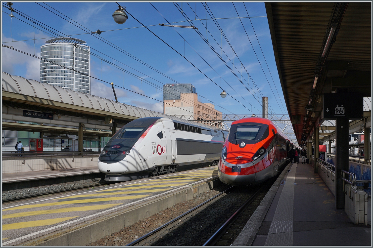 Der FS Trenitalia Freccia Rossa ETR 400 031 ist als FR 6647 von Paris Gare de Lyon nach Lyon Perrache unterwegs. Das Bild zeigt den formschönen Zug beim einzigen Zwischenhalt in Lyon Part Dieu. Links im Bild ist ein inOui TGV zu sehen.

13. März 2024
