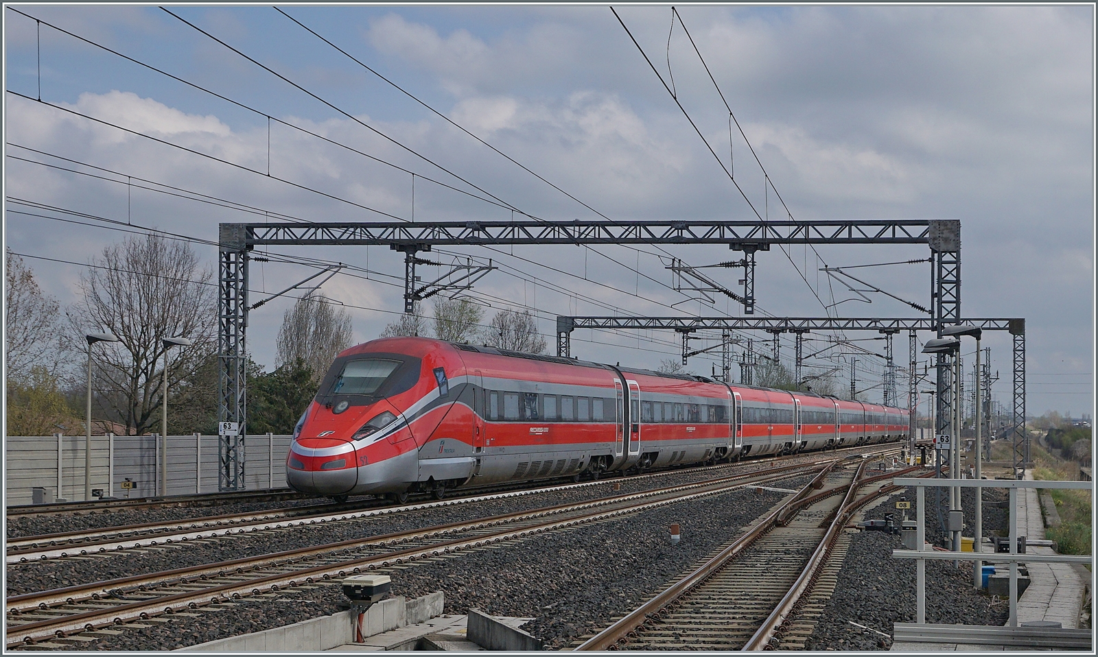 Der nachfolgende FS Treniatlia wird durch den voraus gefahrenen Zug etwas abgebremst. Der ETR 400 052 ist als Frecciarossa 1000 9631 von Milano (ab 13.00) nach Napoli (an 17:30) unterwegs. 

14. März 2023