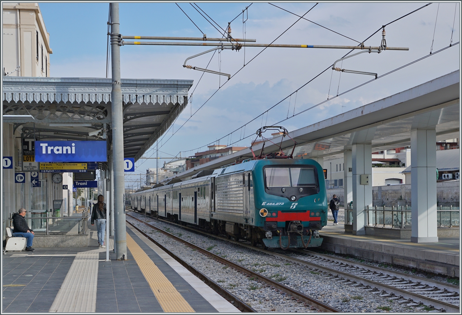 Der schiebenden FS Trenitalia E 464 123 ist in Trani mit einem Regioalzug in Richtung Bari unterwegs. Trotz der vielen neuen Fahrzeuge sind hin und wieder weiterhin älter Züge im Einsatz, bei welchem ie hier die FS Tpy 73 Niederflurzug (Carrozza vicinale a piano ribassato) in XMPR Lackierung mit einem npBD an der Spitze und vier nB Wagen zum Einsatz kommen. 

20. April 2023
