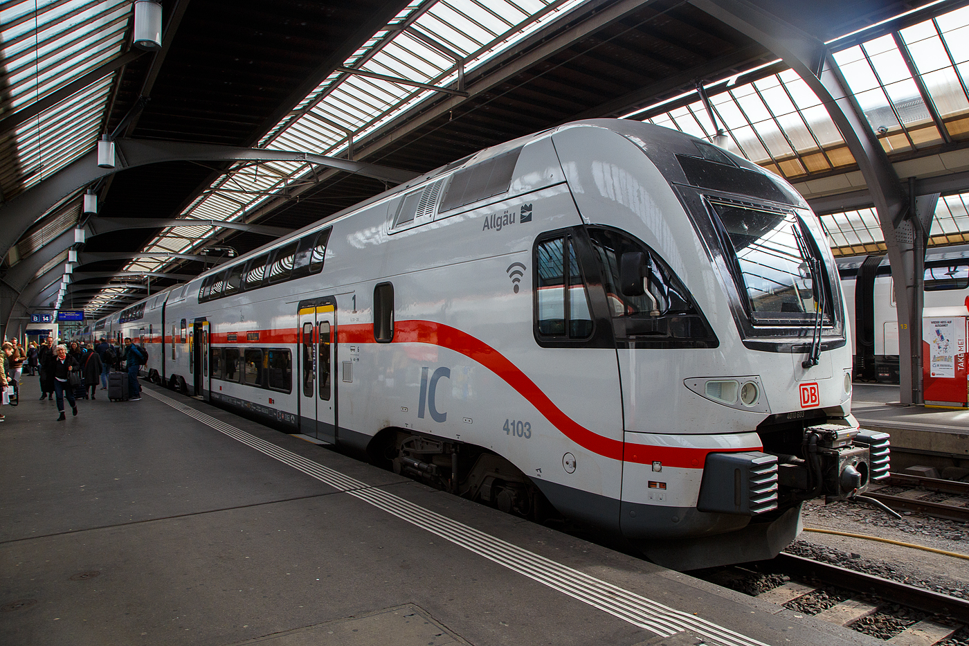 Der sechsteilige Stadler KISS 4010 103 (93 85 4010 103-8 CH-DB ff)  IC2 4103  Allgäu  der DB Fernverkehr AG (ein ex Westbahn KISS) hat als IC 485 von Singen(Hohentwiel) am 21.03.2023 Zürich HB erreicht.

 KISS  - das heißt: Komfortabler Innovativer Spurtstarker S-Bahn-Zug.

Nicht nur die DB Regio AG setzt auf die  KISS -Doppelstockzüge des Schweizer Herstellers Stadler Rail bzw. Stadler Pankow, auch DB Fernverkehr erweitert seine Intercity 2-Flotte durch den Kauf von 17 hochwertigen gebrauchten Doppelstockzügen dieses Typs, die bisher bei der österreichischen Westbahn im Einsatz waren. Die Fahrzeuge sind größtenteils erst zwei Jahre alt und haben bei den Kunden in Österreich höchste Zufriedenheitswerte erreicht.

Ursprünglich wurde das Fahrzeugkonzept für S-Bahnen entwickelt. Längst ist die KISS-Plattform aber weiterentwickelt worden für schnelle Regional-Express-Linien und es gibt sogar eine Fernverkehrsvariante mit sehr komfortabler Innenausstattung und einer Druckertüchtigung für das Befahren von Tunnels mit 200 km/h und einem entgegenkommenden 300 km/h-Zug. Mit einer S-Bahn hat das nur noch in einer Disziplin zu tun: Nämlich eine enorm gute Beschleunigung!

Was können diese Neuerwerbungen:
Die hochwertigen Kiss-Züge, die bisher bei der Westbahn fuhren, sind bis zu 200 km/h schnell und bestehen aus vier bzw. sechs Wagen. Nach den Anpassungen für den Intercity-Einsatz verfügen sie über rund 300 bzw. 470 Sitzplätze. Auf zwei Etagen gibt es komfortable Sitzlandschaften und viel Bewegungsfreiheit. Die Fahrzeuge sind mit WLAN und Steckdosen (je Sitzplatz eine) ausgestattet sowie einem modernen Fahrgastinformationssystem. Auch ein gastronomischer Service mit heißen und kalten Getränken, süßen und herzhaften Snacks sowie frischen Baguettes ist vorgesehen: Unsere Gäste werden die Wahl haben, ob sie sich am Platz bedienen lassen oder ob sie es sich in einem der beiden Cafébereiche gemütlich machen. Die vorhandenen Bereiche für Reisende mit Mobilitätseinschränkungen, für Gepäck und Fahrräder werden entsprechend üblicher DB-Standards sukzessive erweitert.

TECHNISCHE DATEN:
Erste Inbetriebnahme: Dezember 2022
Anzahl der Züge: 8 (7x 1. Bau Serie & 1x 2. Bau Serie)
Zuglänge: 150 m
Anzahl angetriebener Achsen: 8
Zugleergewicht: 316 t
Höchstgeschwindigkeit:200 km/h
Auslandseinsatz möglich: ja (A, CH)
Sitzplätze: 486 (inklusive 19 Klappsitze), davon 62 in 1. Klasse
Fahrradstellplätze: 8
Kinderwagenstellplätze: 2
