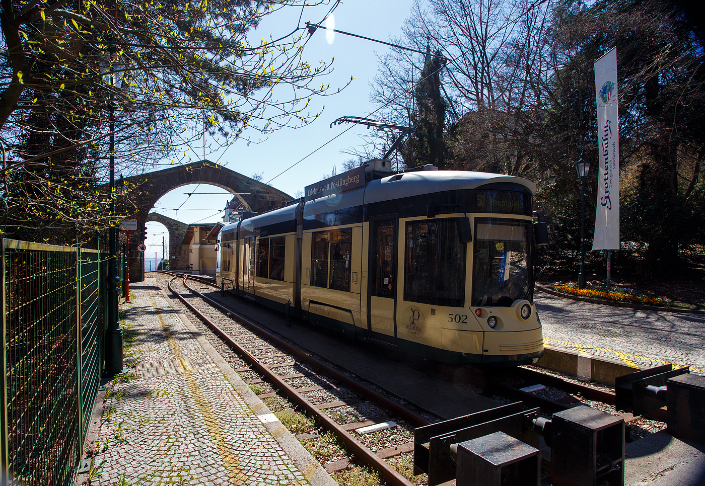 Der Triebwagen 502, ein dreiteiliger vierachsiger Zweirichtungs-Niederflur-Gelenktriebwagen vom Typ Bombardier „Mountainrunner“ hat am 04 April 2025 als Linie 50 (der Linz Linien GmbH) die Bergstation Pöstlingberg (519 m ü.M.) erreicht. Die Pöstlingbergbahn wurde auf 900 mm umgespurt und ist seit 2009 mit dem übrigen Netz der Straßenbahn Linz verknüpft, aber für die Linie braucht man ein separates Ticket.  

Die Pöstlingbergbahn wird, wie das gesamte Straßenbahnnetz, von der Linz Linien GmbH betrieben und gilt, mit einer maximalen Steigung von 116 ‰, als eine der steilsten Adhäsionsbahnen der Welt. Seit 1898 beeindruckt die Linzer Pöstlingbergbahn Gäste aus aller Welt mit ihrer außergewöhnlichen und idyllischen Streckenführung.

Von 2008 bis 2009 wurde die Pöstlingbergbahn revitalisiert und bis zum Hauptplatz verlängert. Trotz massiver Umbau- und Erneuerungsarbeiten blieb die „alte“ Streckenführung erhalten und der ursprüngliche Charakter der Bergbahn wurde bewahrt. Auch die typische eingleisige Streckenführung zwischen den Haltestellen „Landgutstraße“ und „Pöstlingberg“ mit den drei Ausweichstellen blieb unverändert. Die alten Wartehütten wurden wieder originalgetreu aus Holz nachgebaut.

Pünktlich zum 111-Jahre-Jubiläum wurde die Bahn nach den Umbauarbeiten am 29. Mai 2009 wieder eröffnet. Die sanfte Revitalisierung brachte für die Fahrgäste eine deutliche Verbesserung von Komfort, Sicherheit und Barrierefreiheit. Die neuen Niederflurwagen wurden dem Aussehen der alten Wagen nachempfunden. Im Gegensatz zu den historischen Wagen können nun auch Fahrgäste mit eingeschränkter Mobilität die Pöstlingbergbahn problemlos nutzen. Leider verkehrt an Werktagen nur im 30-Minuten-Interval, daher kann es bei schönem Wetter vorkommen das die Triebwagen überfüllt sind. 

Bei einer Streckenlänge von 4,14 km überwindet die Pöstlingbergbahn einen Höhenunterschied von 255 Meter in 20 Minuten, wobei die eigentliche 2,88 km lange Bergstrecke beim Bahnhof Urfahr beginnt. Hier befindet sich auch die ehemalige Talstation. Die Spurbreite wurde zwischen 2008 bis 2009 von 1.000 mm auf 900 mm angepasst. So ist eine Fahrt im Netz der LINZ AG LINIEN problemlos möglich und die Verlängerung bis zur neuen Talstation
„Hauptplatz“ ein weiterer Beitrag zur Attraktivierung der Pöstlingbergbahn. Denn nun ist der Start- und Zielpunkt mitten im Herzen von Linz und speziell für Touristen leicht zu erreichen. 

Fuhrpark:
Als Fahrzeuge kommen vier als „Mountainrunner“ bezeichnete Niederflurfahrzeuge aus der Familie der Bombardier Cityrunner zum Einsatz, die 2009 (TW 501 bis 503) und 2011 (TW 504) von Bombardier in Wieng ebaut wurden. Außerdem wurden die drei Fahrzeuge VIII, X, XI des historischen Fahrzeugsbestands von Meterspur auf 900 mm umgebaut und finden ebenfalls Verwendung.

Die Niederflur-Gelenktriebwagen vom Typ Bombardier „Mountainrunner“ sind dreiteilige vierachsige Zweirichtungs-Niederflur-Gelenktriebwagen. Die Triebwagen wurden in einem „Retro-Design“ gestaltet. Anders als andere Cityrunner besitzen die Linzer Fahrzeuge (auch die der Straßenbahn) durchgehende Radsatzwellen (konventionelle Drehgestelle) und längs an den Seiten angeordneten Motore. Lediglich die Laufwerksrahmen sind dabei noch im Wesentlichen baugleich. Aufgrund der durchgehenden Radsatzwellen musste der Fußboden im Laufwerksbereich auf 450 mm über der Schienenoberkante angehoben werden. Zur sonstigen Bodenhöhe von 365 mm und der Einstiegshöhe von 320 mm gibt es jedoch keine Stufen, sondern Rampen mit einer Neigung von 6 %. Jeder Endfahrzeugkasten ruht auf einem Drehgestell, das Mittelteil als Sänfte ausgeführt. Als Bremsen kommen statt der „früheren“ Zangenbremsen nun Magnetschienenbremsen zum Einsatz.

TECHNISCHE DATEN:
Spurweite: 900 mm 
Achsformel: Bo’Bo’
Länge über Alles: 19.160 mm
Breite: 2.400 mm
Kleinster Halbmesser: 43 m 
Leergewicht: 28.000 kg
Dienstgewicht: 35.000 kg
Höchstgeschwindigkeit: 50 km/h (Ebene) / 25 km auf Bergstrecke
Leistung: 4 x 143 PS (4 x 105 kW)
Motore: 4 Stück luftgekühlten Drehstrom Asynchronmotoren 
Maximale Steigung: 11,6 %
Fahrdrahtspannung: 600 Volt DC
Anzahl Sitzplätze: 33
Anzahl Stehplätze: 55
