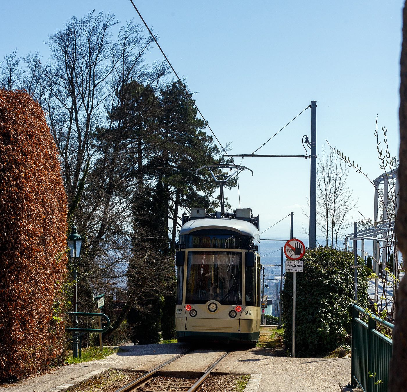 Der Triebwagen 502, ein dreiteiliger vierachsiger Zweirichtungs-Niederflur-Gelenktriebwagen vom Typ Bombardier „Mountainrunner“ verlsst am 04 April 2025 die Bergstation Pstlingberg (519 m .M.) und fhrt als Linie 50 (der Linz Linien GmbH) hinab zum Hauptplatz in Linz.  

Die Pstlingbergbahn wurde von 1.000 mm auf 900 mm umgespurt und ist seit 2009 mit dem brigen Netz der Straenbahn Linz verknpft die auch auf der Spurweite 900 mm fhrt.  Aber fr die Linie 50 „Pstlingbergbahn“ braucht man ein separates Ticket.  

Die Pstlingbergbahn wird, wie das gesamte Straenbahnnetz, von der Linz Linien GmbH betrieben und gilt, mit einer maximalen Steigung von 116 ‰, als eine der steilsten Adhsionsbahnen der Welt. Seit 1898 beeindruckt die Linzer Pstlingbergbahn Gste aus aller Welt mit ihrer auergewhnlichen und idyllischen Streckenfhrung.