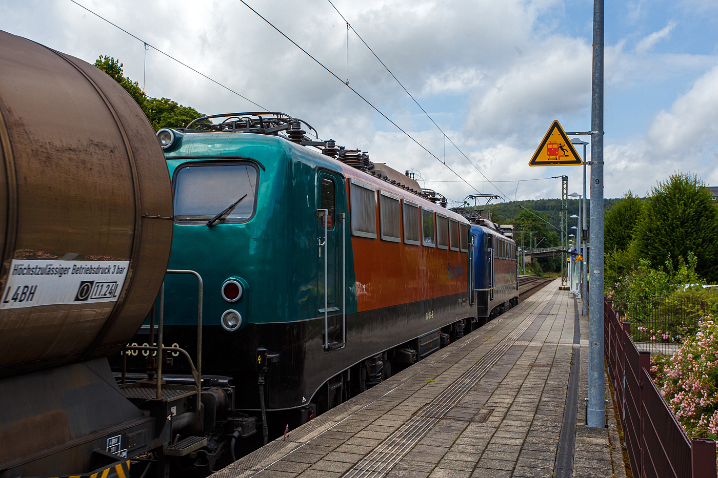 Die 139 287-7 (91 80 6139 287-7 D-BYB) mit der kalten 140 850-9 (91 80 6140 850-9 D-BYB) beide von der BayernBahn GmbH fahren am 04 Juli 2024 mit dem sogenannten  Henkelzug  (Langenfeld/Rhld. nach Gunzenhausen), durch den Bahnhof Kirchen (Sieg) in Richtung Siegen.

Die 139 287-7:
Vorne die 139 287-7 wurde 1963 von Krauss-Maffei AG in München-Allach unter der Fabriknummer 18956 gebaut, er elektrische Teil ist von den Siemens-Schuckert-Werke (SSW) in Berlin. Als DB E10 287 wurde in Dienst gesetzt, mit der Einführung des EDV-Nummernsystems wurde sie zum 01.01.1968 zur DB 110 287–0. Die Lok ist mit Einholmstromabnehmern ausgerüstet, sie ist die letzte gebaute Kasten 110er. Zur 139er wurde sie erst 1994 nach einem Umbau, der Lokkasten wurde auf Drehgestelle der Baureihe 140 (E40) gesetzt und es folgte die Umzeichnung in DB 139 287-7. Zum Mai 2009 erfolgte die Z-Stellung bei der DB AG. Zum 1.Oktober 2011 wurde die Lok durch die BayernBahn GmbH erworben und erhielt anschließend eine Untersuchung. Die Neulackierung in kobalt-blau/orange erhielt sie dann 2017.

Die 140 850-9
Die (E40) 140 850-9 wurde 1972 bei Henschel & Sohn in Kassel unter der Fabriknummer 31696 gebaut, der elektrische Teil wurde von der AEG in Berlin unter der Fabriknummer 8804 geliefert/gebaut. Als 140 850-9 wurde sie an die Deutsche Bundesbahn ausgeliefert, die Ausmusterung bei der DB Cargo AG erfolgte im Juli 2017 und sie wurde an die BayernBahn GmbH in Nördlingen verkauft.