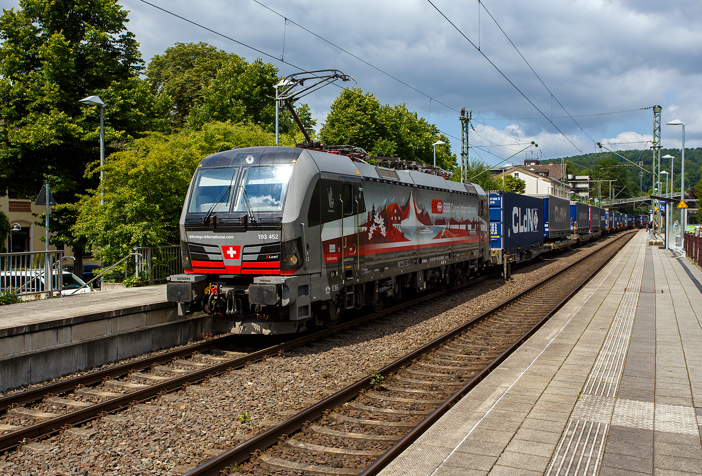 Die an die SBB Cargo International AG vermietete mit „XLoad“ ausgestattete 193 452  Helvetia  (91 80 6193 452-0 D-SIEAG) der SüdLeasing GmbH, Stuttgart (eingestellt in Deutschland durch Siemens) fährt am 17 Juli 2025 mit einem KLV-Zug, durch Kirchen (Sieg) in Richtung Köln.

Die Multisystemlokomotive Siemens Vectron MS wurde 2024 von Siemens Mobilitiy in München-Allach unter der Fabriknummer 23637 gebaut. Sie wurde in der Variante A40-1a ausgeführt und hat so die Zulassung für Deutschland, Österreich, die Schweiz, Italien, die Niederlande und Belgien (D / A / CH / I / NL / B). Sie verfügt über eine Leistung von 6,4 MW (160 km/h) und ist neben den nationalen Zugsicherungssystemen mit dem Europäischen Zugsicherungssystem (ETCS BL3) ausgestattet. Zudem ist sie mit der neuen Ausrüstungspaket XLoad ausgestattet. 

Das neue XLoad Ausrüstungspaket für Vectron:
XLoad ist ein Ausrüstungspaket für Vectron, welches künftig mitbestellt, aber auch bei bereits ausgelieferten Vectron Loks nachgerüstet werden kann. Das Feature verbessert die Reibwertausnutzung und ermöglicht dadurch höhere Anhängelasten. Zudem reduzieren die Fahreigenschaften, die das Feature bewirken, den Verschleiß von Rad und Schiene.

Aktuell sind die Schweizer Vectron-Lokomotiven (SBB Cargo und BLS Cargo) in der Regel in Doppeltraktion unterwegs. Die Steigungen und Rampen der Schweizer Berge sind vor allem bei schlechten Witterungsbedingungen nicht ohne. Eine Lokomotive muss auch bei geringerem Schlupf genügend Traktion auf die Schienen bringen, um alle Güter sicher und zuverlässig ans Ziel zu bringen. Ein effizienter Weg aus dieser «Misere» ist die für Vectron entwickelte Zusatz-Funktion «XLoad». Den erfolgreichen Beweis trat eine SIEMENS Testlokomotive im Frühjahr 2022 bei der SBB Cargo International und bei der BLS Cargo eindrücklich an. 

Für SBB Cargo International bewies die Test-Lokomotive am Bözberg und für BLS Cargo an der Nordrampe des Lötschbergs ihre enorme Zugkraft. 
Vectron meisterte im Frühjahr 2022 die lange 12‰-Steigung des Bözbergs mit einer Anhängerlast von 2.000 Tonnen bravourös. Bei den nächtlichen Testfahrten zeigte sich eindrücklich die enorme Zugkraft der Lokomotive. 

Am Lötschberg wurden bei der BLS Cargo steigungsmäßig noch ein paar Promille draufgepackt. Mit 1.020 Tonnen im Gepäck bewältigte die Vectron-Lokomotive mit XLoad-Feature die 27‰-Steigung der Nordrampe ebenfalls meisterlich. Und auch diverse Anfahrtsversuche absolvierte der mit dem XLoad-Feature aufgerüstete Vectron problemlos. So bestellte die SüdLeasing GmbH (Stuttgart) im Auftrag der SBB Cargo International jüngst 20 Vectron Lokomotiven mit XLoad bei SIEMENS.

