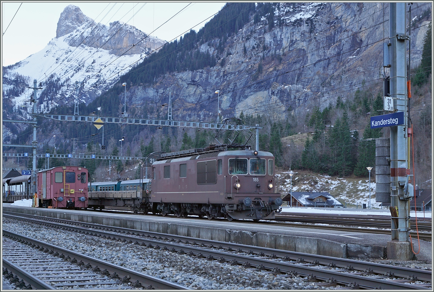 Die Autotunnelzüge der Strecke AT1 (und AT2 in der Hochsaiseon) nach Kandersteg (bzw. Iselle) sind im Bahnhof von Kandersteg fotografisch gesehen an einer sehr ungeschickt Stelle zu finden und somit kaum fotografier bar. Die Strecke bis zum Tunnel bietet jedoch gute Möglichkeiten, die letzten im Einsatz befindlichen BLS Re 4/4 zu fotografieren. Ich blieb trotzdem an Bahnhof von Kandersteg und konnte die BLS Re 4/4 185 mit ihrem Autotunnelzug im Bahnhof fotografieren. Der Zug wartet auf die Abfahrt des BLS RABe 521 als R1 von Domodossola nach Bern, um dann als Dienstzug in Richtung Frutigen zu fahren.

3. Jan. 2024 