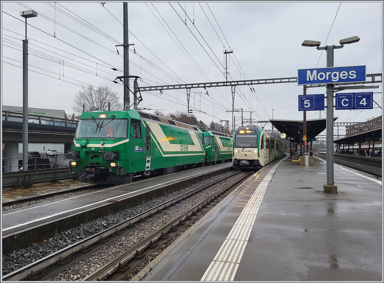 Die beiden BAM MBC Ge 4/4 22 und 21 warten in Morges mit ihrem Güterzug nach Apples auf die Abfahrt.
Rechts im Bild steht der Regio R 76 nach Bière.  
22. Feb. 2024 