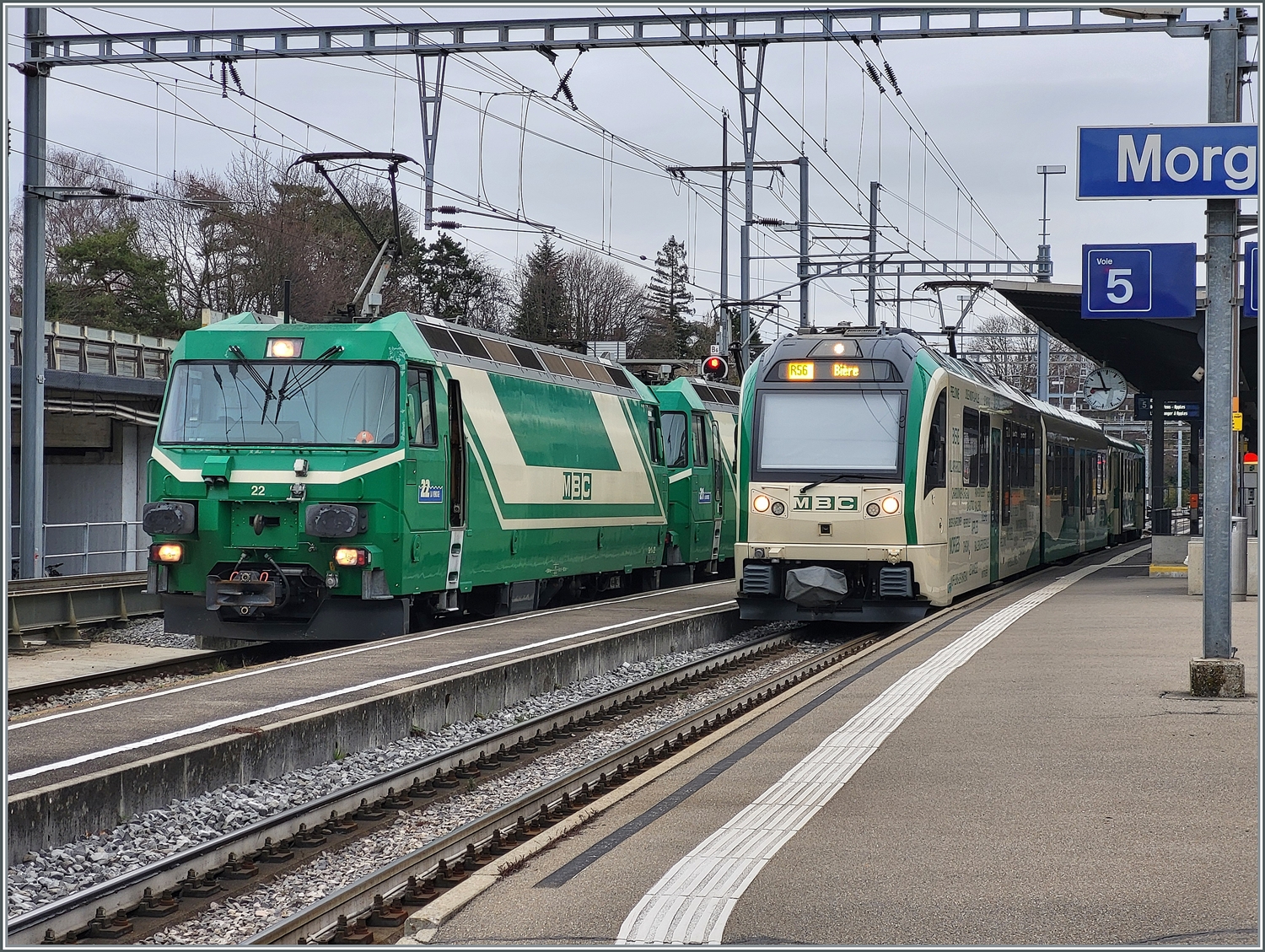 Die beiden BAM MBC Ge 4/4 22 und 21 stehen nun mit ihrem Kieszug in Morges zur Abfahrt nach Apples bereit. Daneben steht ein BAM MBC SURF Be 4/4 - B - Bt als Regionalzug R 56 nach Biere. 

4. März 2024