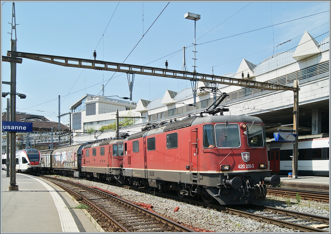Die beiden SBB Re 4/4 II 11250 (Re 420 250-3) und Re 4/4 II 11248 (Re 420 248-7) warten mit einem langen Güterzug aus Hbbillns Wagen in Lausanne auf die Blockdistanz zum IR 90 und somit auf ihre Weiterfahrt.

26. Juni 2024