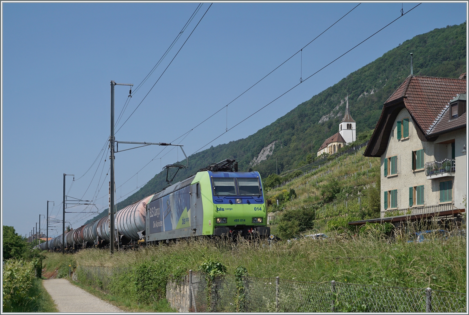Die BLS Re 485 014 mit einem Güterzug auf der Fahrt in Richtung Bie/Bienne bei Ligerz. Zur Zeit wird der kurze, einspurige Abschnitt auf Doppelspur umgebaut (Tunnel im Berg), so dass dieser schöne Streckenabschnitt auf absehbare Zeit verschwinden wird, doch allem Anschein nach verzögert sich die Inbetriebnahme des Tunnels bis 2029. 

