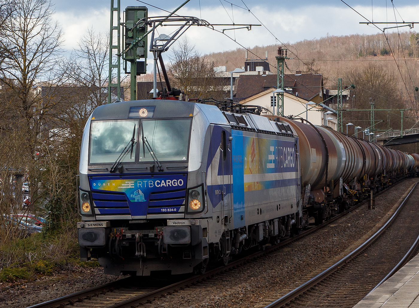 Die für die Rurtalbahn Cargo GmbH fahrende Vectron 193 824-0   Düren  (91 80 6193 824-0 D-Rpool) der Railpool GmbH (München), fährt am 19.03.2021 mit einem Kesselwagenzug durch den Bahnhof Kirchen (Sieg) in Richtung Köln.

Die SIEMENS Vectron AC (200 km/h - 6.4 MW) wurde 2016 von SIEMENS Mobilitiy in München unter der Fabriknummer 22054 gebaut. Sie hat die Zulassung für D/ A und H (RO durchgestrichen).