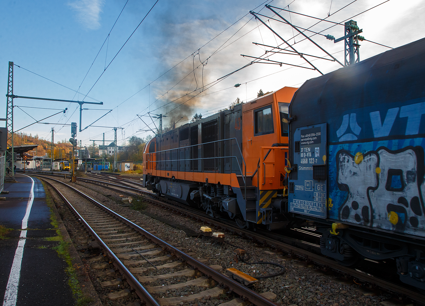 Die KSW 43 (92 80 1273 018-2 D-KSW), die asymmetrische Vossloh G 2000 BB der KSW (Kreisbahn Siegen-Wittgenstein) hat am 18.11.2022, mit ihrem Coilzug (VTG Coilwagen der Gattung Shimmns-ttu) vom Hafen Duisburg kommend, Betzdorf (Sieg) erreicht. Da die Strecke nach Herdorf (KBS 462 – Hellertalbahn) noch nicht frei war musste sie kurz im Rbf warten. Nun da der HLB Triebwagen als RB 96 Betzdorf erreicht hat (hinten im Bild) ist die Strecke frei und sie kann weiter nach Herdorf fahren.

Nochmal einen lieben Gruß an das Lokpersonal zurück.
