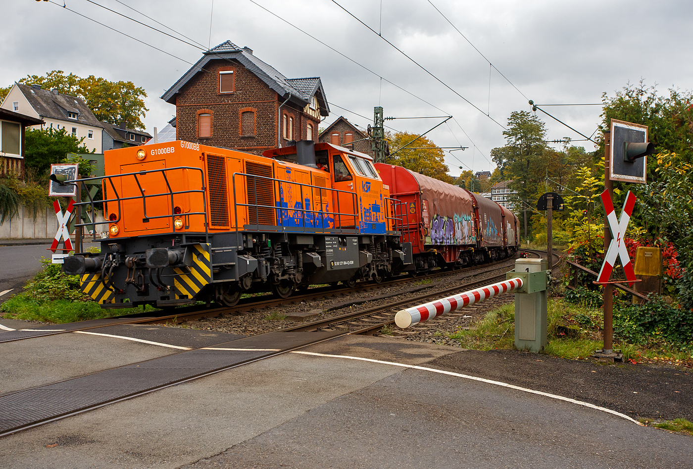 Die KSW 44 (92 80 1271 004-4 D-KSW) eine MaK G 1000 BB der KSW (Kreisbahn Siegen-Wittgenstein) fährt am 09 Oktober 2025, mit einem Coilzug, beim Bü km 121,192 durch Kirchen/Sieg in Richtung Betzdorf/Sieg.

In Betzdorf/Sieg setzt die Lok dann um und es geht dann über die Hellertalbahn (KBS 462) nach Herdorf. 

Die Lok 44 wurde 2003 unter der Fabriknummer 1001462 bei Vossloh gebaut und am 05.01.2004 an die damalige SK - Siegener Kreisbahn GmbH geliefert, welche ab Ende 2004 nun als Kreisbahn Siegen-Wittgenstein (KSW) firmiert.