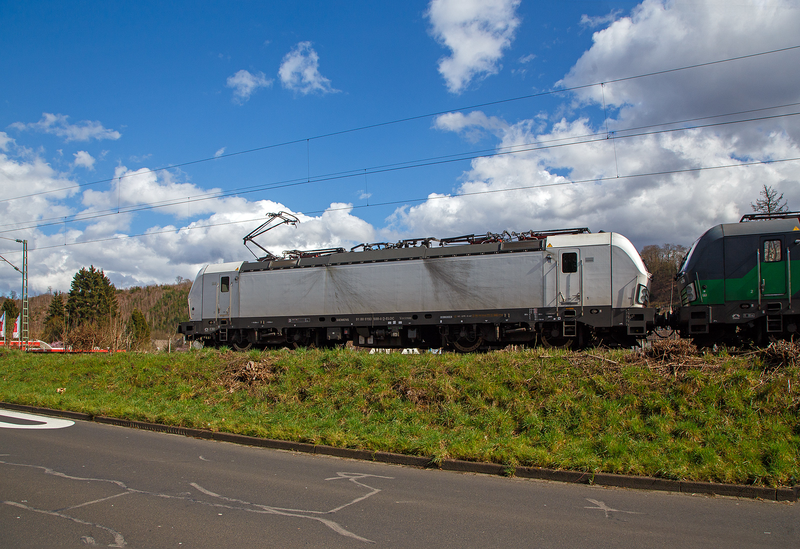 Die weiße SIEMENS Vectron MS 193 598-0 (91 80 6193 598-0 D-ELOC) fährt am 24.03.2023, mit der kalten SIEMENS Vectron AC 193 229-2 (91 80 6193 229-2 D-ELOC) und einem beladenen Autotransportzug, durch Kirchen (Sieg) in Richtung Siegen.