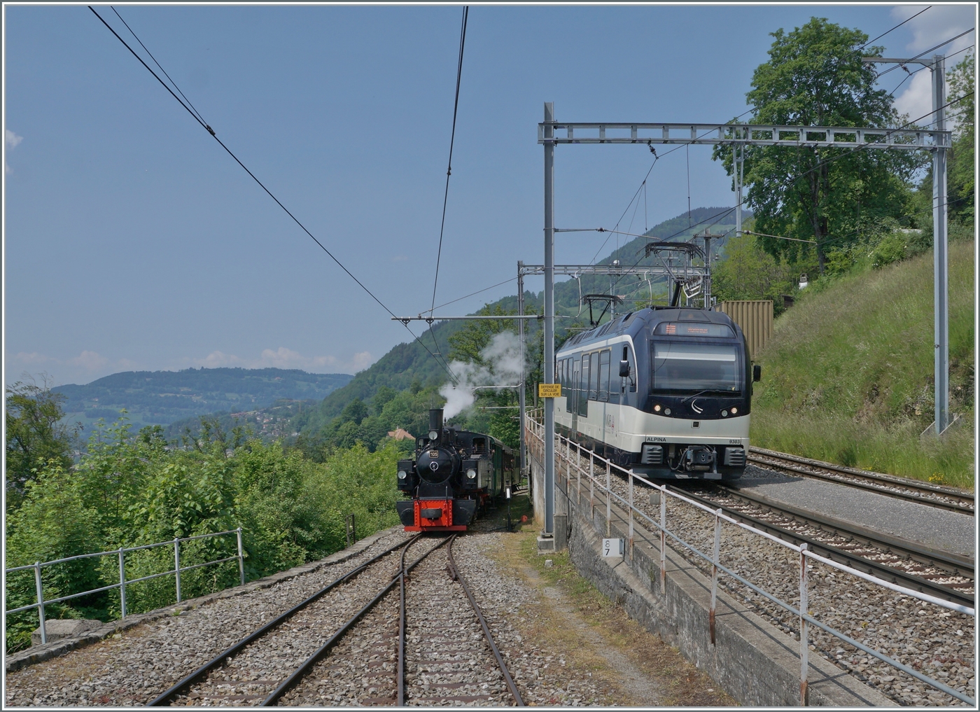 Durch die Grösse des Bahnhofs Chamby und des Betriebsgeschehen ein eher seltenes Ereignis: Paralleleinfahrt des MOB GoldenPass Panoramic 2221 mit dem Alpina ABe 4/4 9303 und dem Blonay-Chamby Dampfzug mit der SEG G 2x 2/2 105.

28. Mai 2023