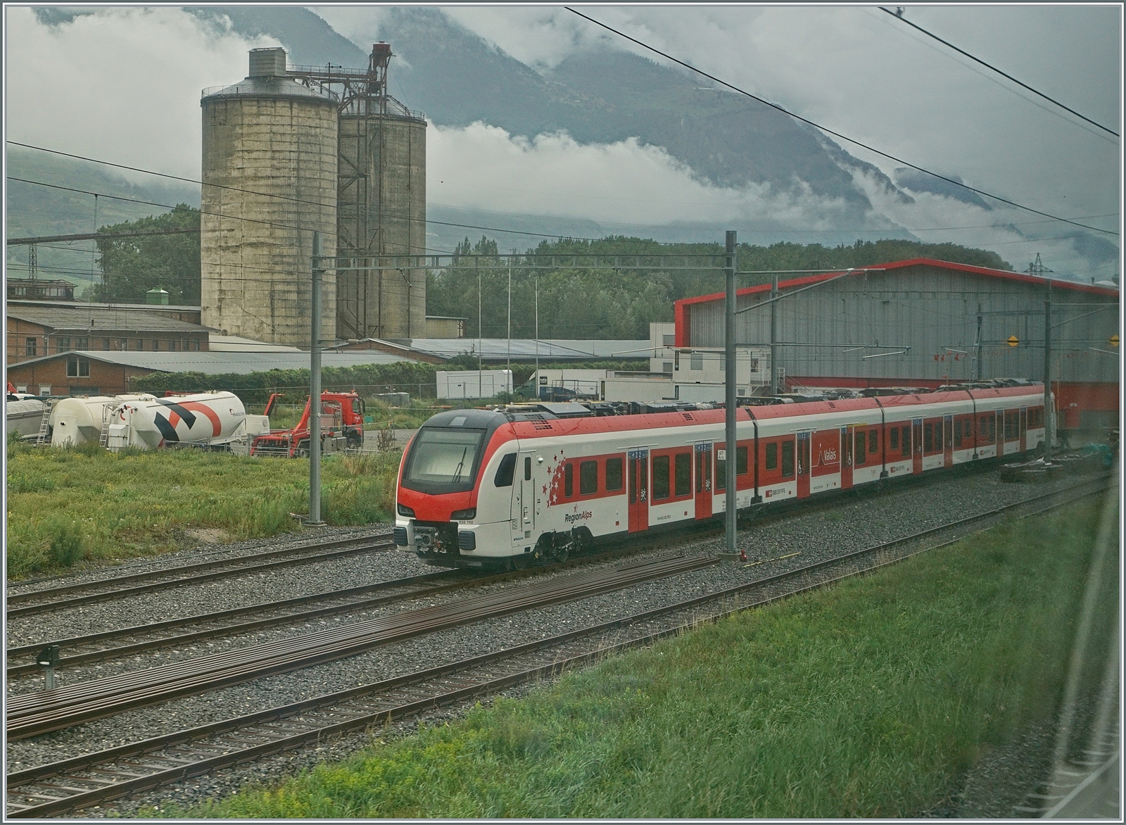 Durchs Fenster fotografiert: Vor der neuen TMR Halle/Depot steht der RegionAlps RABe 533 702. Am fr�hen Morgen standen sogar zwei RABe 533 Triez�ge hier.

17. Aug. 2024