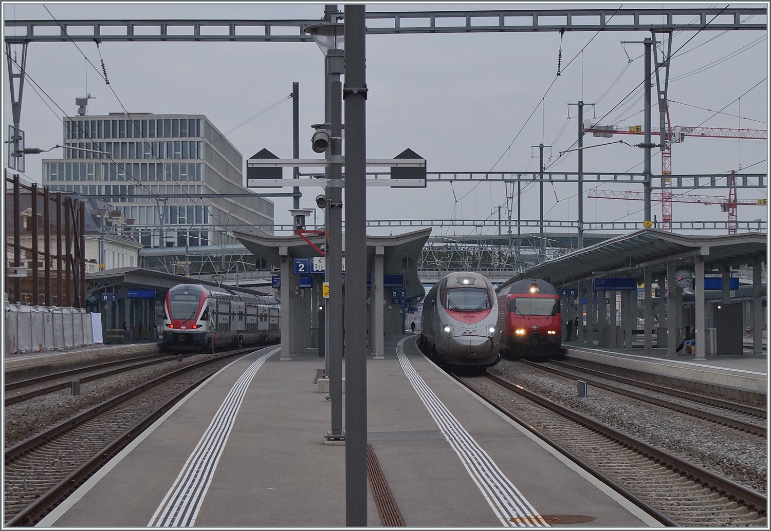 Ein Bahnhof voller Züge: Links ein SBB RABe 511 als RE 33 nach Annemasse, in der Mitte ist ein FS Trenitalia ETR 610 als EC 37 auf der Durchfahrt und rechts im Bild wartet eine SBB Re 460 mit ihrem IR von Neuchâtel auf die Abfahrt nach Lausanne.

29. Feb. 2024