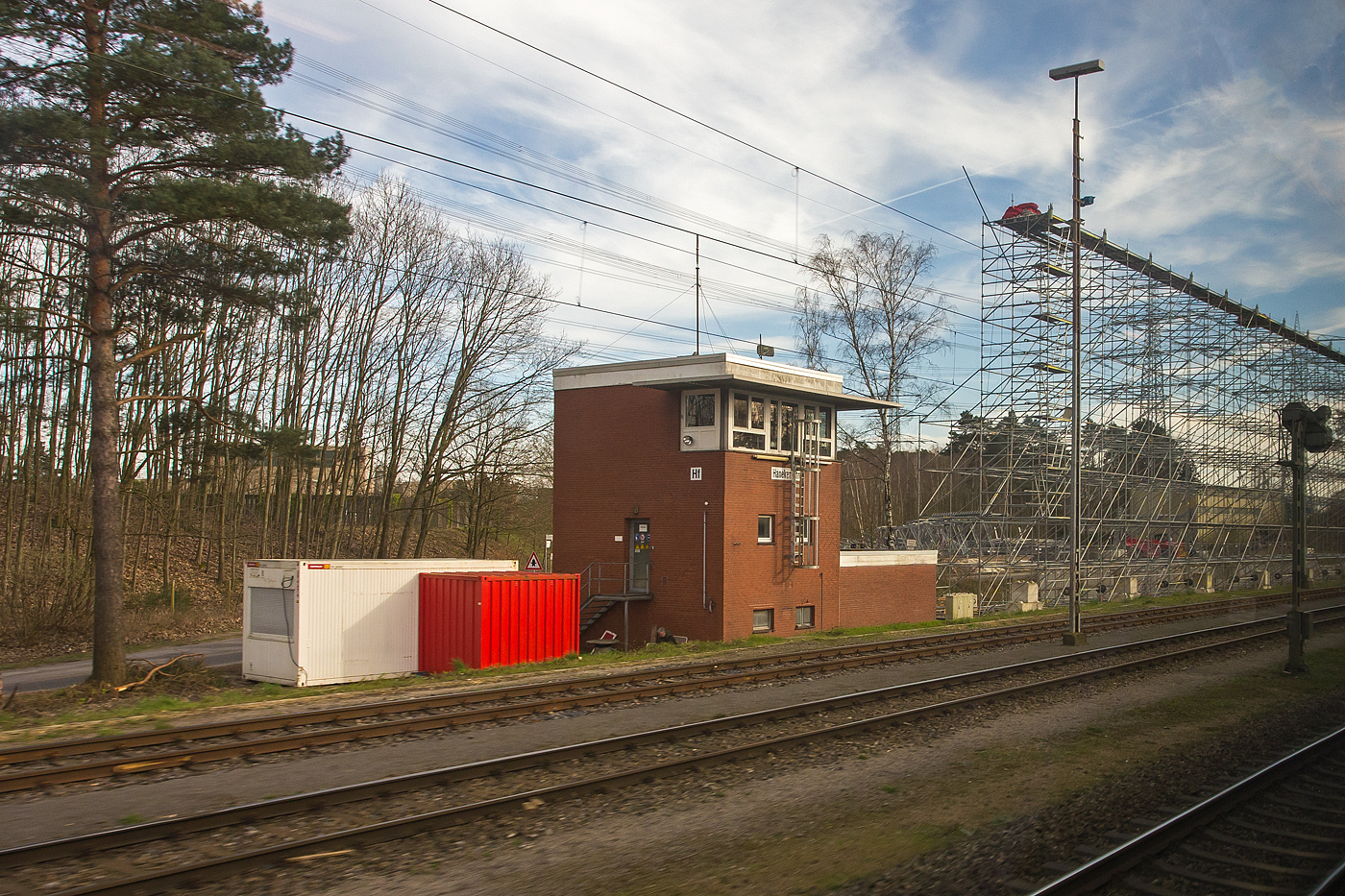 Ein Blick aus dem Zug auf das elektromechanische Stellwerk Hanekenfhr Fahrdienstleiter „Hf“ am 14 Mrz 2024. Das aktive Stellwerk ist in der Bauform VES 1912 (E43) mit Glhlampenberwachung. 

Das Stellwerk Hanekenfhr befindet sich sdlich von Lingen an der Emslandstrecke KBS 395 Rheine - Emden – (Norddeich Mole) und liegt zwischen den ehemaligen Kernkraftwerken Lingen und Emsland.