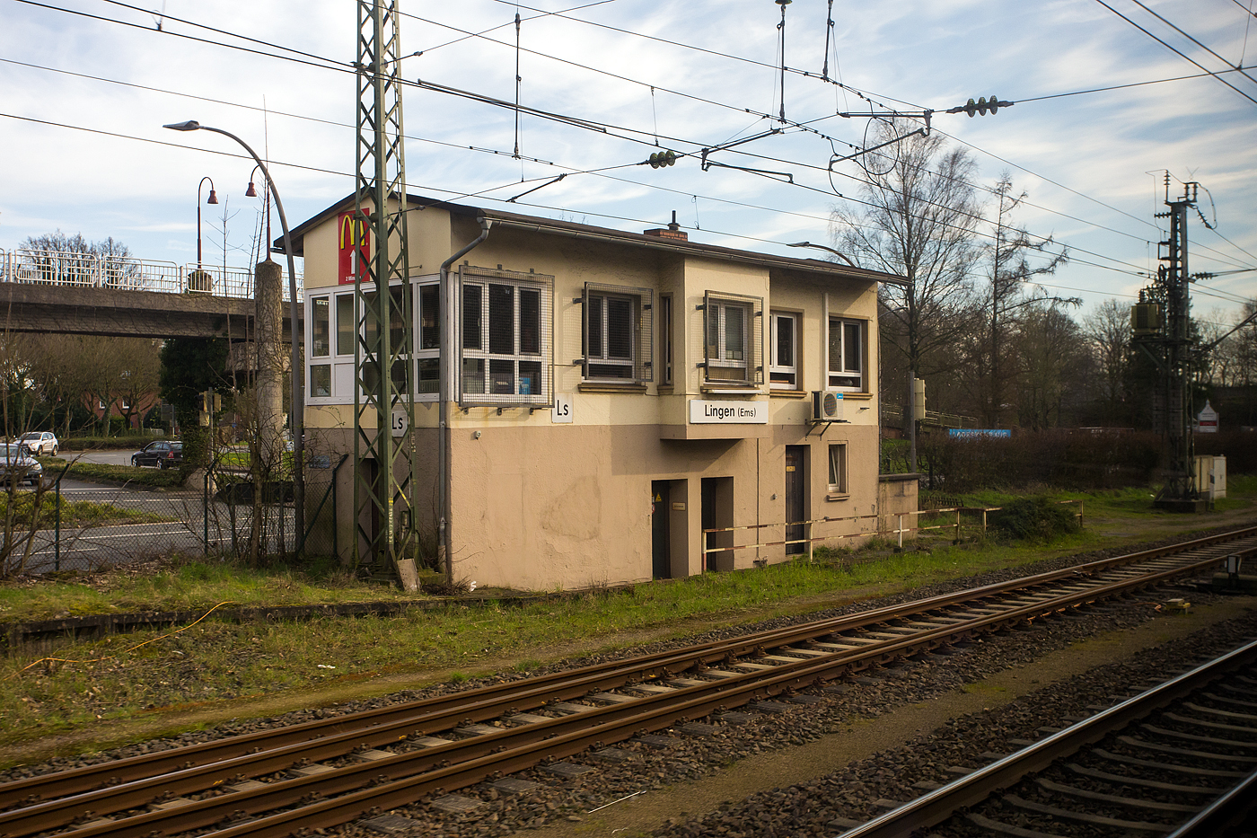 Ein Blick aus dem Zug auf das elektromechanische Weichenwrter Stellwerk Lingen (Ems) Sd „Ls“ am 14 Mrz 2024. Das aktive Stellwerk ist in der Bauform VES 1912 (E43) mit Farbscheibenberwachung.