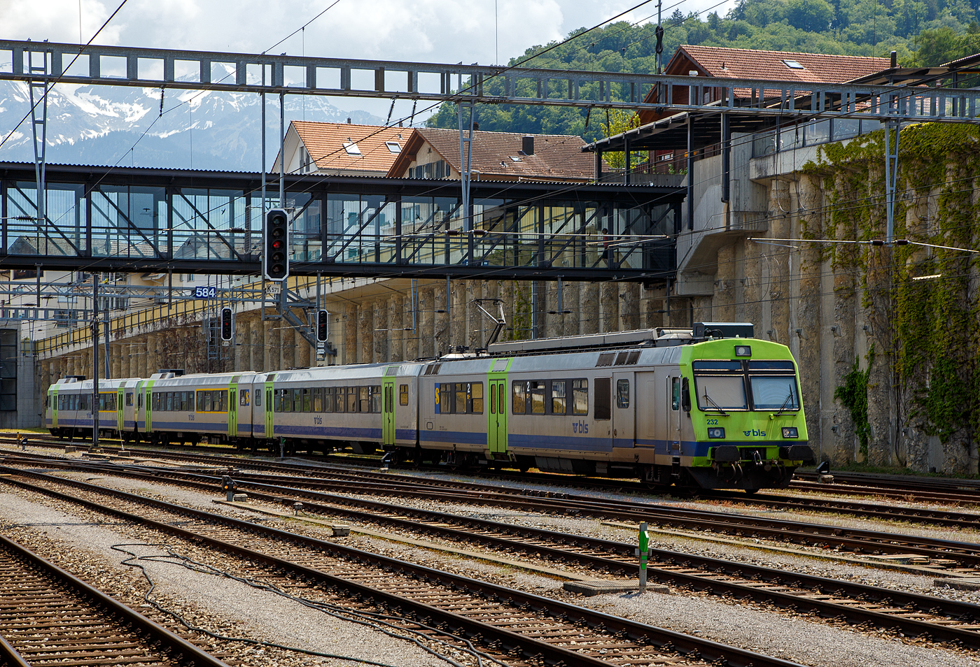 Ein BLS NPZ ist am 28.05.2023 beim Bahnhof Spiez abgestellt. 
Der sogenannte «Privatbahn-NPZ» besteht hier (vierteilig) aus:
•	Triebwagen RBDe 566 232-5 (94 85 7 566 232-5 CH-BLS), ex EBT RBDe 4/4 II – 232 (Emmental-Burgdorf-Thun-Bahn, seit 2006 BLS);
•	2. Klasse Zwischenwagen (Lieferung 1991–92) B 50 85 20-35 517-5 CH-BLS, ex EBT B 50 38 20-34 517;
•	1./2. Klasse Steuerwagen Abt 932 / 50 85 80-35 932-3 CH-BLS, ex EBT ABt 50 38 39-33 932, ex EBT Bt 932, sowie dem weiteren
•	1./2. Klasse Steuerwagen ABt 933 / 50 85 80-35 933-1 CH-BLS, ex EBT ABt 50 38 39-33 933, ex EBT Bt 933.

Die ursprünglichen RBDe 4/4II der EBT-Gruppe, heute RBDe 566-II (230–242), sind Pendeltriebzüge (Elektro-Triebwagen mit Zwischen- und Steuerwagenwagen) für den Einsatz im Regionalverkehr der BLS AG. Zusammen mit der zweiten Serie der BLS RBDe 565 beschaffte 1984 bis 85 auch die EBT-Gruppe (ab 1997 RM - Regionalverkehr Mittelland, seit 2006 BLS) 13 sogenannte «Privatbahn-NPZ». Diese sind mit den Zügen der BLS weitestgehend identisch, außer dass die Steuerwagen ohne 1. Klasse als Bt gebaut wurden. Zudem ist die Adernbelegung der Vst III unterschiedlich. In den Jahren 1991/92 erhielten alle EBT/SMB/VHB-Steuerwagen ein 1. Klasse Abteil und wurden so zu ABt. Die RBDe 4/4 erhielten die Bezeichnung RBDe 566, die Steuer- und Zwischenwagen erhielten 1991/92 zwölfstellige UIC-Nummern. Die RM-Nummern wurden nach der Fusion mit der BLS Mitte 2006 beibehalten. 

Ab 2009 durchliefen die Züge eine Modernisierung analog den RBDe 565, außer jenen Punkten, die bei den RBDe 566 II bereits ausgeführt sind. Dabei werden auch die ehemaligen RM-Nummern durch TSI-Nummern ersetzt. Bei den Zwischenwagen erfolgte dies konzentriert im Jahre 2011. Die Kompositionen wurden nach und nach von Rot auf das Lindengrün der BLS umlackiert.

Die Triebwagen werden nach und nach verschrottet und durch den neuen MIKA ersetzt. Die Steuerwagen ABt 50 85 80-35 930, 931, 934, 935, 936, 939 und 940 werden zu BDt für die Autopendelzüge umgebaut. Sie werden zusammen mit den modernisierten Re 465 im Einsatz sein.

TECHNISCHE DATEN Triebwagen:
Spurweite: 1.435 mm (Normalspur)
Achsfolge: Bo'Bo' 
Länge über Puffer: 25.000 mm 
Drehzapfenabstand: 17.500 mm
Achsabstand im Triebdrehgestell: 2.700 mm
Gewicht: 72,0 t 
Dauerleistung: 1.650 kW / 2.240 PS
Anfahrzugkraft: 164 kN
Höchstgeschwindigkeit: 125 km/h
Sitzplätze: 55 in der 2. Klasse
Max. Ladegewicht: 4 t
Stromsystem: 15 kV 16⅔ Hz AC

Quellen: BLS, wikipedia
