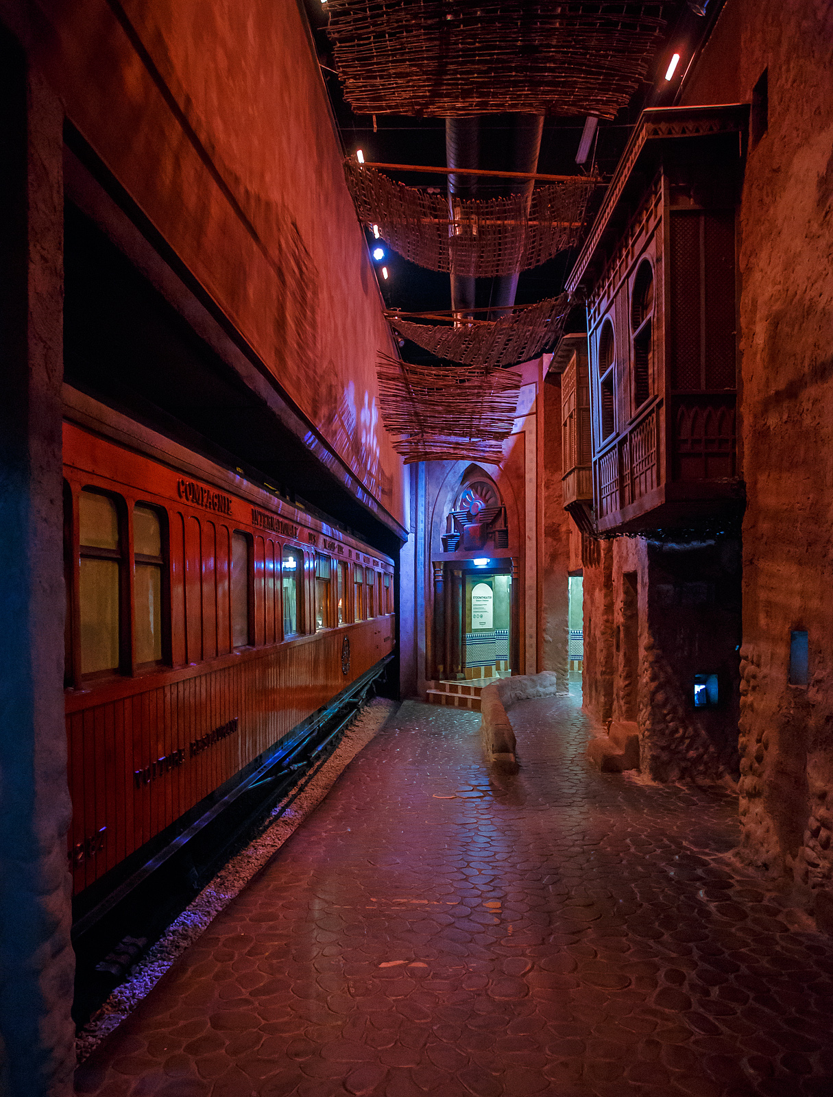 Ein Hauch von Orient in den Niederladen, der Teakholz-Speisewagen WR 2287 ehemals der CIWL - Compagnie Internationale des Wagons Lits et des Grands Express Européens, am 24 Juni 2025 im Het Spoorwegmuseum (bis 2005 NSM - Nederlands Spoorwegmuseum / Niederländischen Eisenbahnmuseum) in Utrecht im ehemaligen Bahnhof Maliebaan.

Der Wagen wurde 1911 von Rába Magyar Waggon- és Gépgyár Reszvénytársaság in Győr, Ungarn (Raab Ungarische Waggon- und Maschinenfabrik Aktiengesellschaft) für die Compagnie Internationale des Wagons Lits et des Grands Express Européens (CIWL) gebaut. 

Am 4. Dezember 1876 gründete George Nagelmackers in Belgien die „Compagnie Internationale des Wagons Lits“. Der Name wurde später zu „et des Grands Express Européens“ erweitert. Das Unternehmen konzentrierte sich hauptsächlich auf Luxusreisezüge auf internationalen Strecken. Die von der CIWL in Auftrag gegebenen Schlafwagen ermöglichten Nachtfahrten und sparten so deutlich Zeit auf langen Strecken. Dank der Speisewagen konnten zudem die bis dahin üblichen Essenspausen entfallen, was eine weitere Zeitersparnis bedeutete.

Außergewöhnliche Sorgfalt wurde auf das Rollmaterial gelegt, wie dieser luxuriöse Teakholzwagen WR 2287 im Museum beweist. Dieser Speisewagen ist einer von vielen luxuriösen Holzwaggons Teakholzwagen, die Wagon Lits für seine internationalen Züge bauen ließ, darunter auch für den bekannten Orient-Express (Paris – Istanbul). Der Wagen war hauptsächlich in Südosteuropa im Einsatz und wahrscheinlich auch im berühmten Orient-Express im Einsatz. 

Der vierachsige Speisewagen verfügt über eine Zentralheizung mit Kohleofen, eine Küche mit Kohleofen, Kühlschränken und verschiedenen Küchenutensilien. Der zweigeteilte Speisesaal bietet 36 Sitzplätze (freistehende und ledergepolsterte Stühle) an jeweils sechs Tischen für 2 bzw. 4 Personen.

Als das Eisenbahnmuseum 1953 eröffnete, bestand der Bedarf, der Öffentlichkeit Erfrischungen anzubieten. Ein hölzerner Speisewagen wurde in Erwägung gezogen, war jedoch in Westeuropa nicht mehr erhältlich. In Ungarn wurde jedoch dieser ehemalige CIWL- Teakholzwagen entdeckt, der noch immer als Dienst-und Arbeitswagen im Einsatz war. Die Werkstatt der Ungarischen Eisenbahn in Dunakeszi, damals noch hinter dem Eisernen Vorhang, restaurierte diesen Waggon vollständig und vorbildlich. Der Wagen kam 1977 ins Eisenbahnmuseum nach Utrecht. Ursprünglich sollte der Wagen vom Museum als Restaurant genutzt werden, aber nach der Renovierung in Ungarn erhielt er einen prominenten Platz in der Sammlung.

In einem solcher Wagen dieser Serie (CIWL 2419 D) wurde 1918 der Waffenstillstand des Ersten Weltkriegs unterzeichnet, 1940 die Kapitulation Frankreichs vor den Deutschen. 

TECHNISCHE DATEN:
Baujahr: 1911
Spurweite: 1.435 mm (Normalspur)
Achsen: 4 (in 2 Drehgestellen)
Achsfolge:	2'2'
Länge über Puffer: 20.400 mm
Sitzplätze: 36
