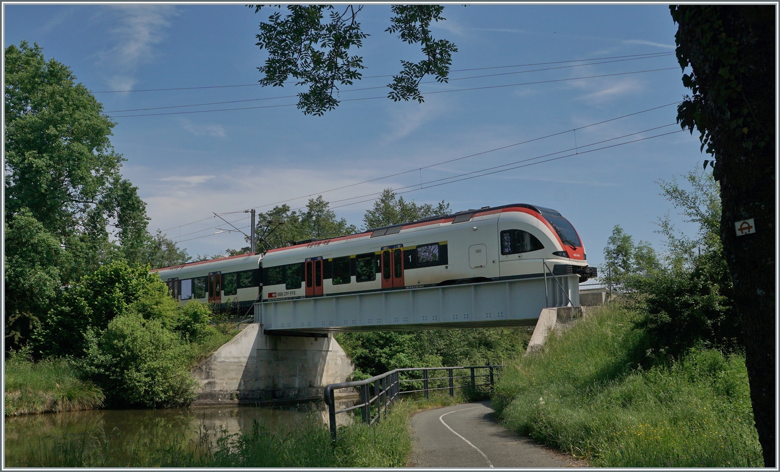 Ein SBB RABe 522 auf dem Weg von Meroux TGV mach Biel/Bienne überquert bei Grandvillard den Reih/Rohne Kanal. 

19. Mai 2021
