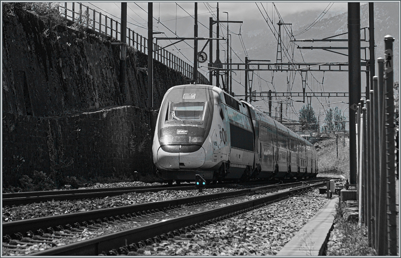 Eine grosse, unerwartet Überraschung: Seit der Umstellung auf ETCS im April 2017 fuhr hier infolge mangelnder ETCS-Ausrüstung der TGV Züge keiner mehr vorbei; bis heute, als mir bei Villeneuve der SNCF inoui Rame 4715 (kein Lyria TGV) begegnete. Das S/W Bild zeigt als kleiner Farbpunkt ein blaues Zwergsignal, welche bei ETCS auf der Strecke Lausanne Villeneuve die klassischen Zwergsignale ersetzt haben. 

4. Juni 2024