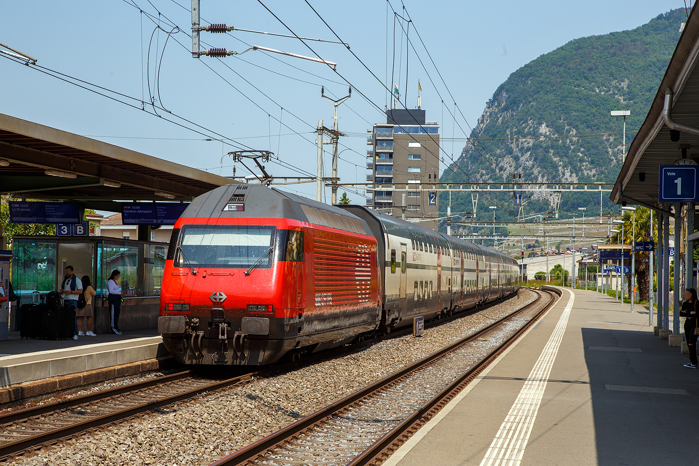 Eine Lok 2000 schiebt eine IC 2000 Garnitur....
Die SBB Re 460 085-4  Pilatus   (91 85 4 460 085-4 CH-SBB) schiebt, einen IC2000 Wagenzug, als  IR 90 (Brig – Lausanne - Genève-Aéroport) vom Bahnhof Aigle weiter in Richtung Lausanne bzw. Genève (Genf). 

Die Lok2000 wurde 1992 von der SLM in Winterthur (Schweizerischen Lokomotiv- und Maschinenfabrik) unter der Fabriknummer 5562 gebaut, der elektrische Teil ist von der ABB (Asea Brown Boveri). Seit 2015 durchlaufen die Loks im SBB Werk Yverdon-les-Bains (VD) das vollständige Modernisierungs-/Refit-Programm LOK2000. So sollen die Loks fit für die nächsten 20 Jahre sein, zudem werden durch alle 119 SBB Re 460 Lokomotiven so etwa 30 Gigawattstunden Energie eingespart.