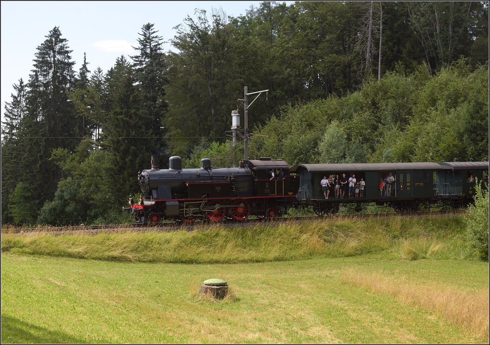 Fahrtag im Z�rcher Oberland. 

Eb 3/5 der BT bei Emmetschloo mit begeisterten Freiluftfahrern im Postwagen FZ 203. Juli 2023.