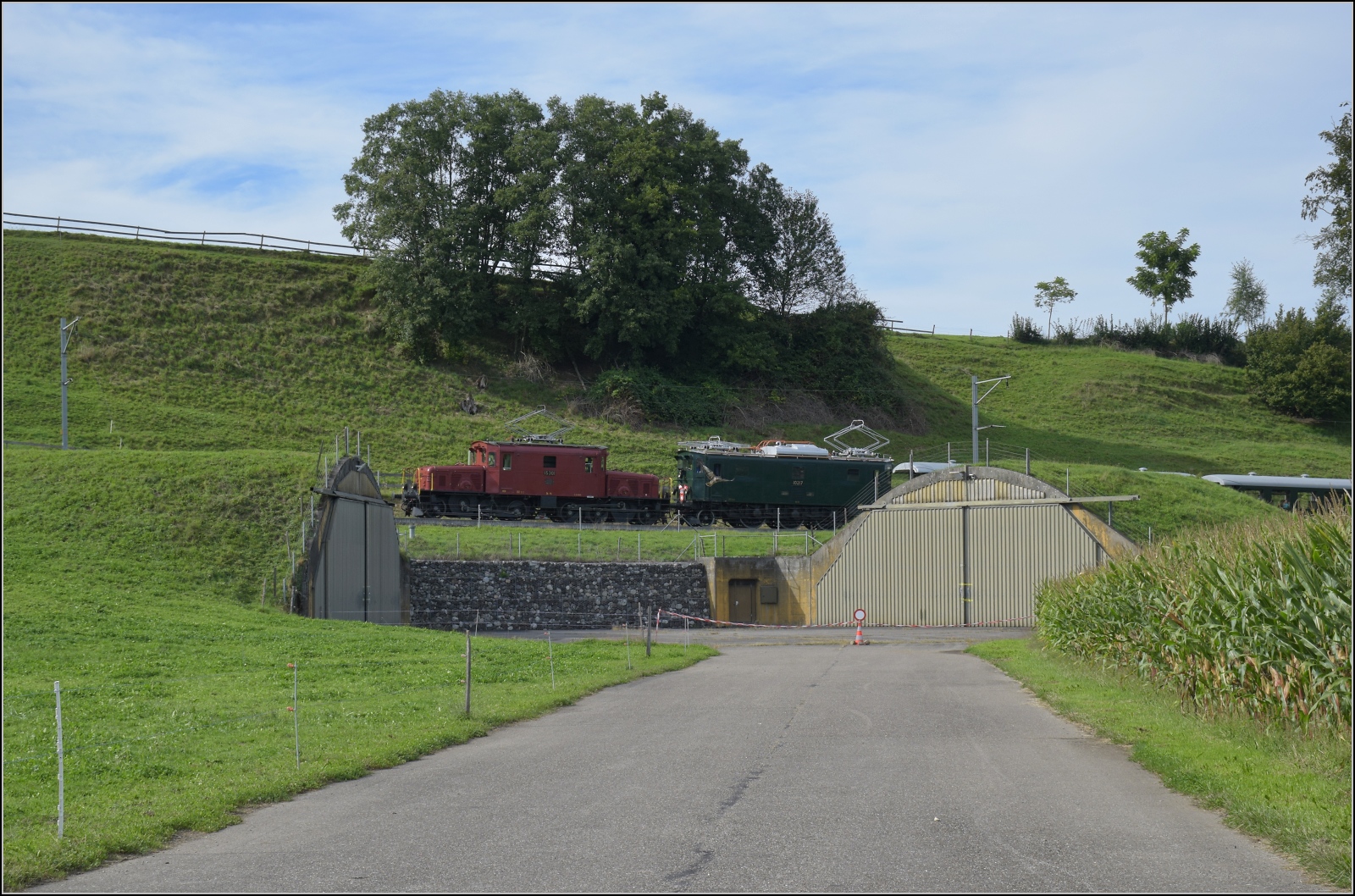 Historische Seethalbahn in Aktion.

Der Museumszug mit Seetalkrokodil De 6/6 15301, A 3/5 10217 und den Seetalwagen fährt oberhalb der Bunkerhangare des Flugplatz Emmen vorbei. September 2024.