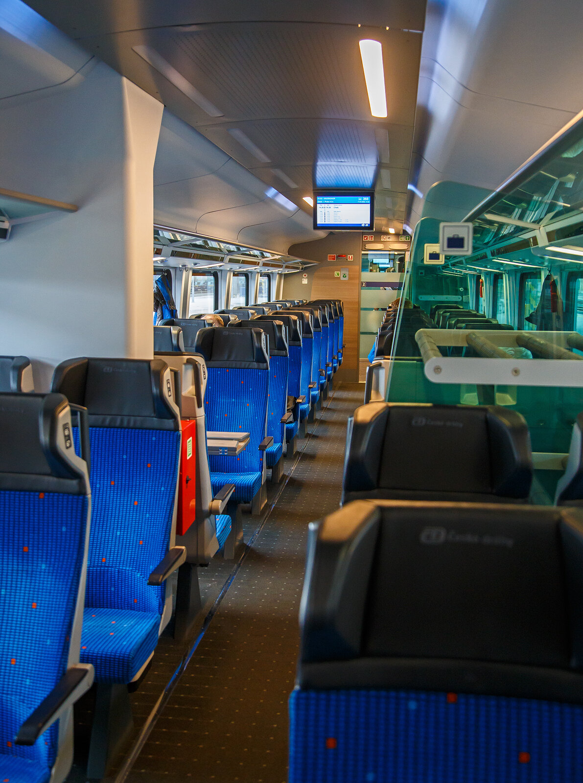 Innenraum von einem  2.Klasse ČD InterJet Groraumwagen der Gattung Bmpz 895 (CZ- ČD 73 54 21-91060 bis 079) der ČD - Česk drhy eingereiht als Wagen 368 in den R15 „Krunohor“ (Cheb - Karlovy Vary - Praha hl.n.), am 17.04.2023 im Bahnhof Cheb (Eger).

Die ČD bestellte 50 Reisezugwagen, in Form von 10 fnfteiligen Wageneinheiten die im regulren Betrieb fest verbunden sind. Diese UIC-Z-Wagen wurden zwischen 2019 und 2021von Siemens Wien (Fertigung) und KODA VAGONKA Ostrava (Montage) gebaut. Die Einheiten haben keinen Steuerwagen, sie sind an beiden Enden mit Schraubkupplungen  und Puffern (Standard Zug-Sto-Einrichtung) ausgestattet. Man geht davon aus, dass sie auf den Strecken Prag – Pilsen – Cheb und Prag – st nad Labem – Chomutov – Cheb eingesetzt werden. Eine Einheit besteht aus einem 1.-Klasse-Wagen, einem 2.-Klasse-Wagen mit Platz fr Rollstuhlfahrer und fr Reisende mit Kindern, zwei 2.-Klasse-Wagen ohne Sonderausstattung und einem 2.-Klasse-Wagen mit Platz fr den Fahrradtransport. 