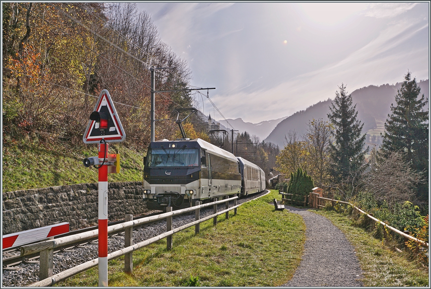 Kurz nach Gstaad erklimmt die MOB Ge 4/4 8002 mit ihrem GoldenPass Express auf der Fahrt von Montreux nach Interlaken die Steigung in Richtung Schönried und wird unmittelbar nach dieser Aufnahme über den Grubenbachviadukt fahren. 

13. Oktober 2024