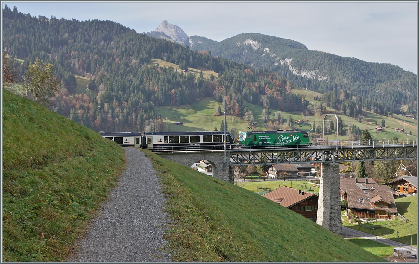Kurz nach Gstaad fährt die MOB Ge 4/4 8004  Swisstainable  mit ihrem GoldenPass Express auf der Fahrt von Interlaken nach Montreux über den Grubenbach Viadukt.

13. Oktober 2024