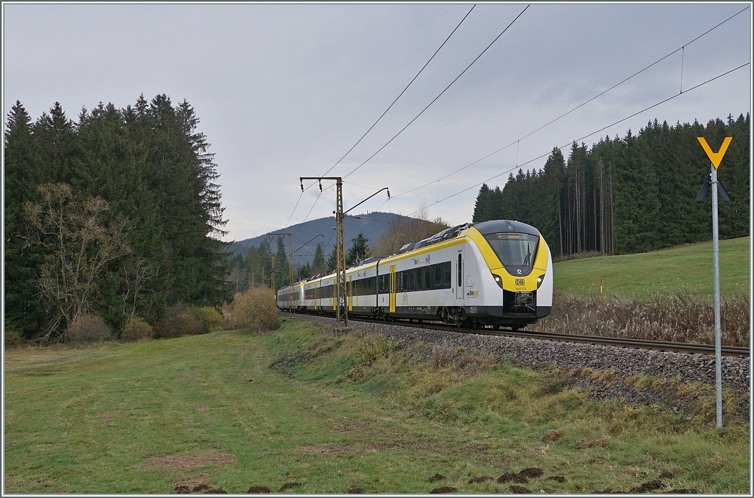 Nachdem der Zug auf dem vorangegangenen Bild etwas  versteckt  zu sehen war, hier an fast derselben Stelle zwischen Titisee und Hinterzarten die bedienen DB 1440 174 und 862 als S 1 9618 von Seebrugg nach Breisach.
Ebenfalls bemerkenswert der noch aus Anfangszeit der Elektrifizierung stammende Fahrleitungsmast, der ursprünglich mit 20000 Volt 50 Hertz gespiesenen Strecke. 

14. November 2022