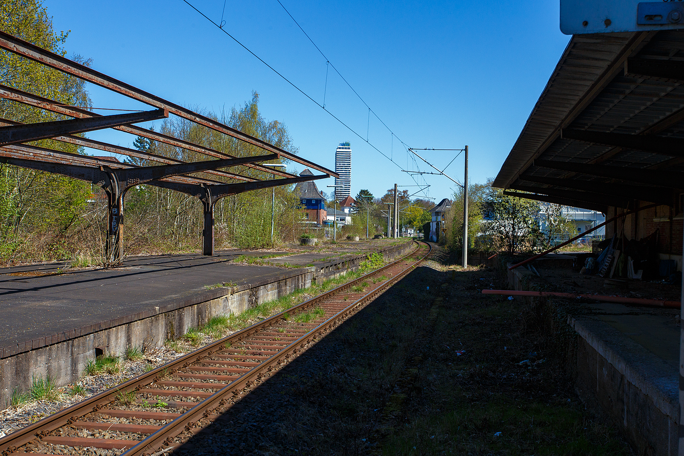 Nicht sehr einladend, der Bahnhof Lübeck-Travemünde Hafen (Hafenbahnhof) am 21 April 2026 in Blickrichtung Strand. Links der aufgegebene Mittelbahnsteig mit den Gleisen 2 (heute Gleis 1) und 3. Auf der Trasse des ehemaligen Gleis 1 am Bahnhofsgebäude befindet sich heute der neue Außenbahnsteig. Und ganz rechts der ehemalige Bahnsteig 1 und das ehemalige Empfangsgebäude.